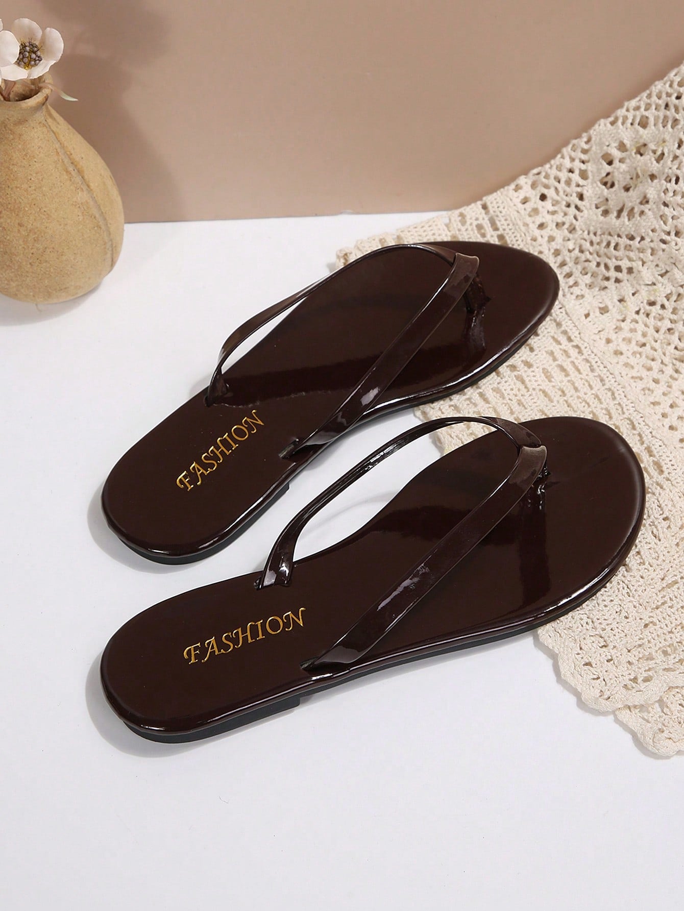 Women's chocolate brown flat flip flop sandals featuring a toe-post thong style and braided detail, suitable for casual indoor and outdoor wear.