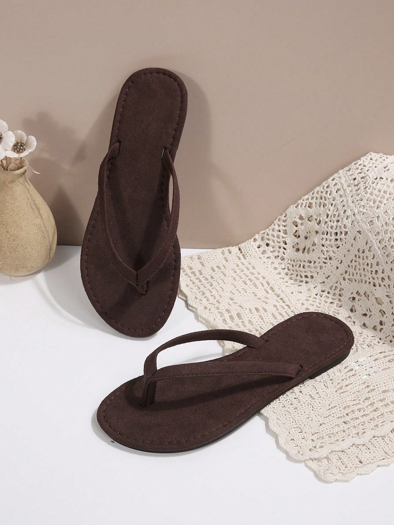 Women's chocolate brown flat flip flop sandals featuring a toe-post thong style and braided detail, suitable for casual indoor and outdoor wear.