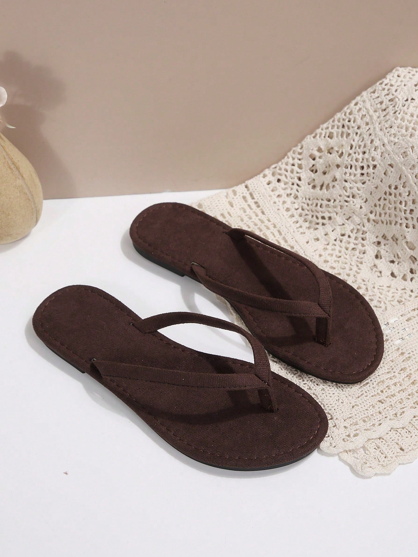 Women's chocolate brown flat flip flop sandals featuring a toe-post thong style and braided detail, suitable for casual indoor and outdoor wear.