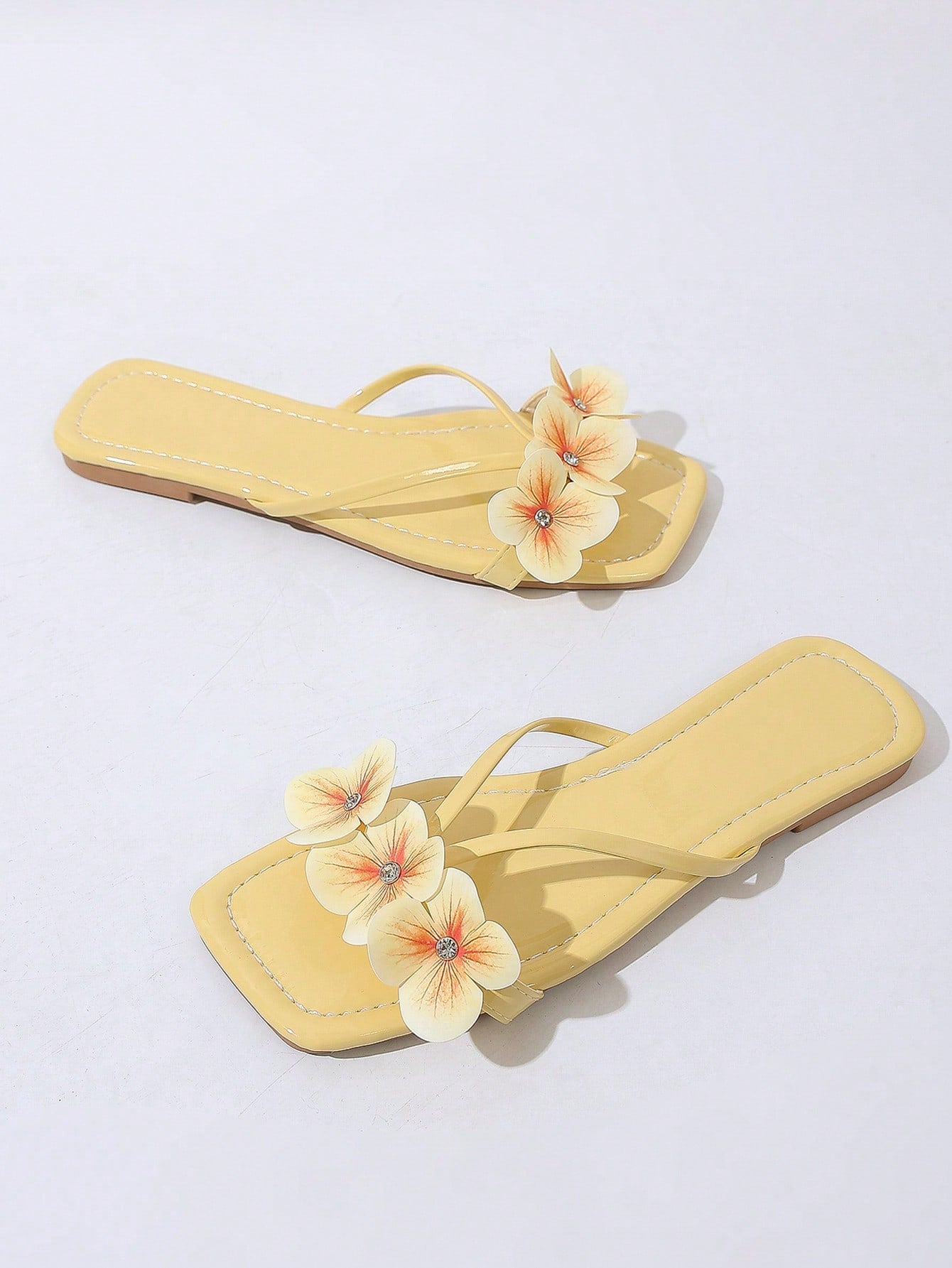 Women's khaki flat slide sandals with open toe, bow tie detail, and floral plant-pattern vacation style design.