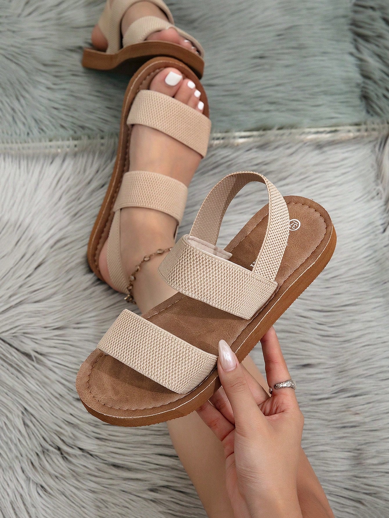 Women's flat slide sandals with ruched fabric, bow accent, and fringe detail, suitable for outdoor vacation wear.
