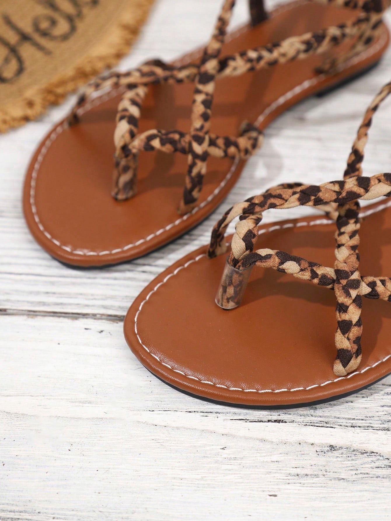 Women's woven criss-cross elastic flat sandals with braided strappy upper and toe post design