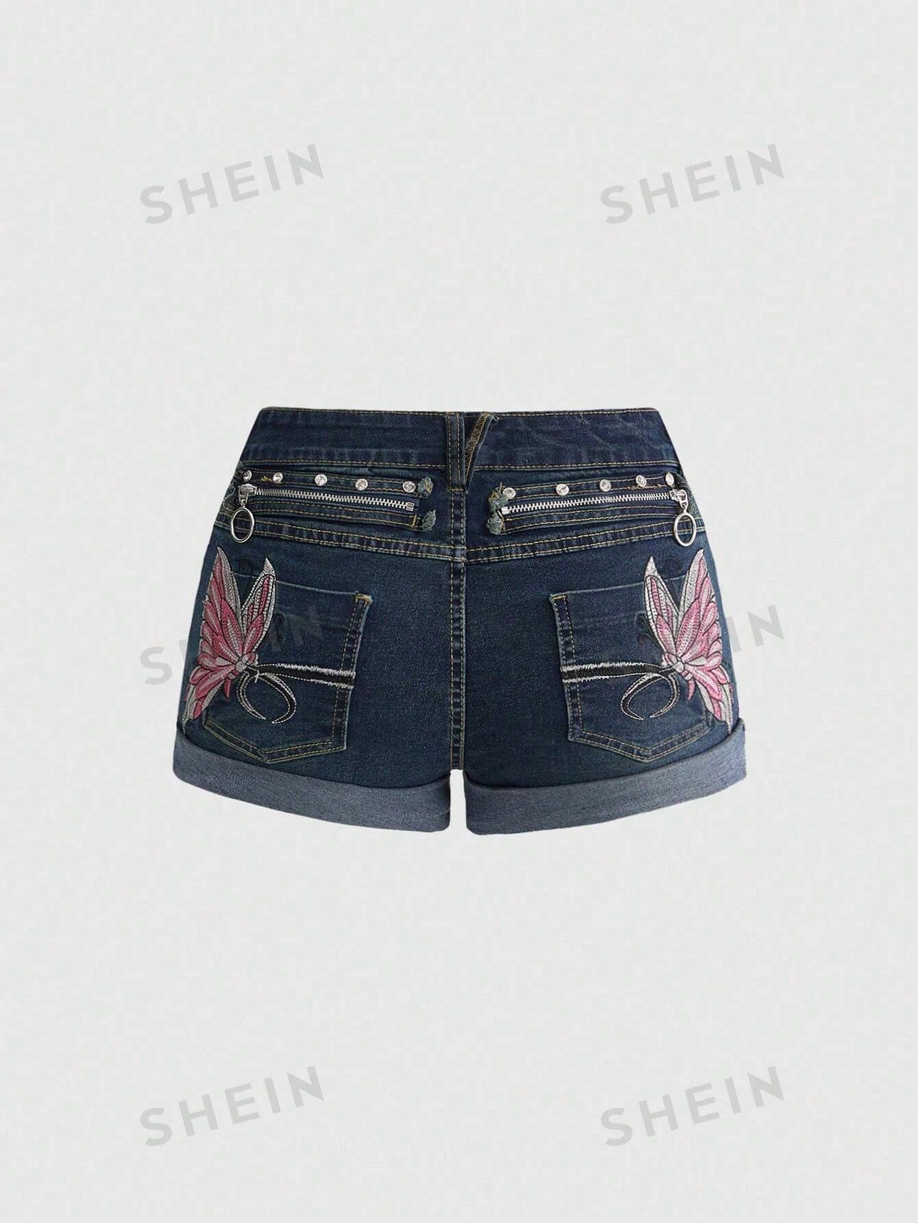 Blue washed shorts with butterfly embroidery, distressed detailing, ultra low waist, button closure, zipper fly, and pockets.