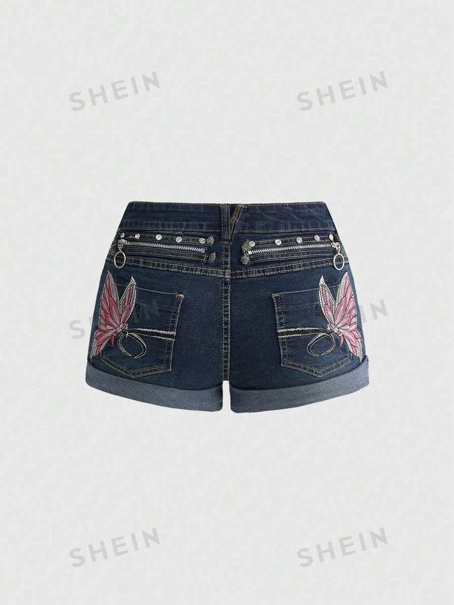 Blue washed shorts with butterfly embroidery, distressed detailing, ultra low waist, button closure, zipper fly, and pockets.