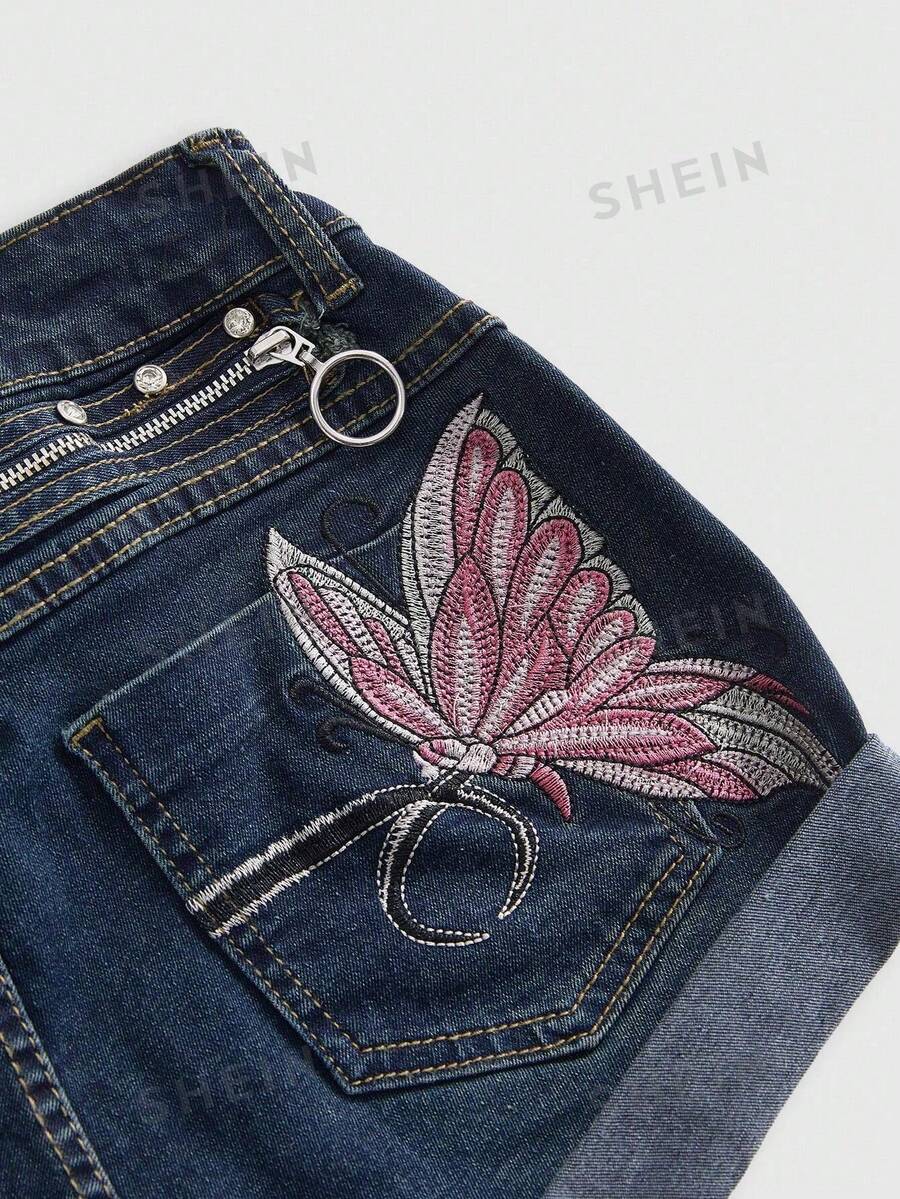 Blue washed shorts with butterfly embroidery, distressed detailing, ultra low waist, button closure, zipper fly, and pockets.