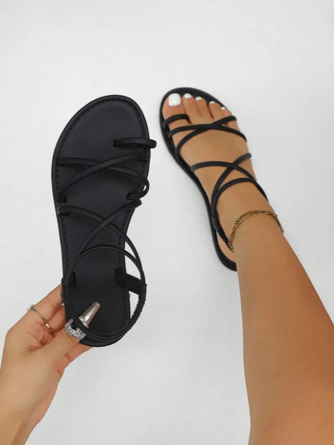 Women's flat gladiator sandals with open round toe, thin criss-cross straps, buckle and elastic back strap, and rhinestone detail for casual daily and vacation wear.
