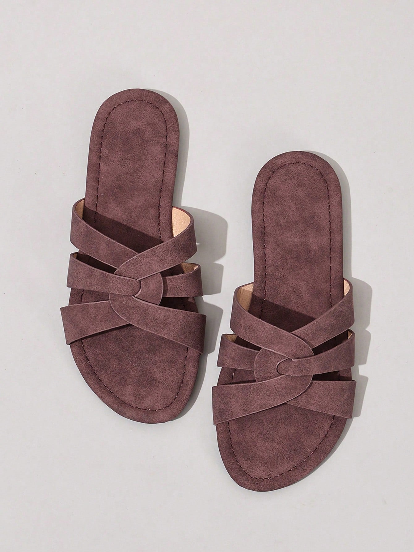 Women’s flat open-toe slide sandals with braided strap detail, embossed texture, and rhinestone decoration, designed as casual slip-on footwear for beach and everyday outdoor wear.