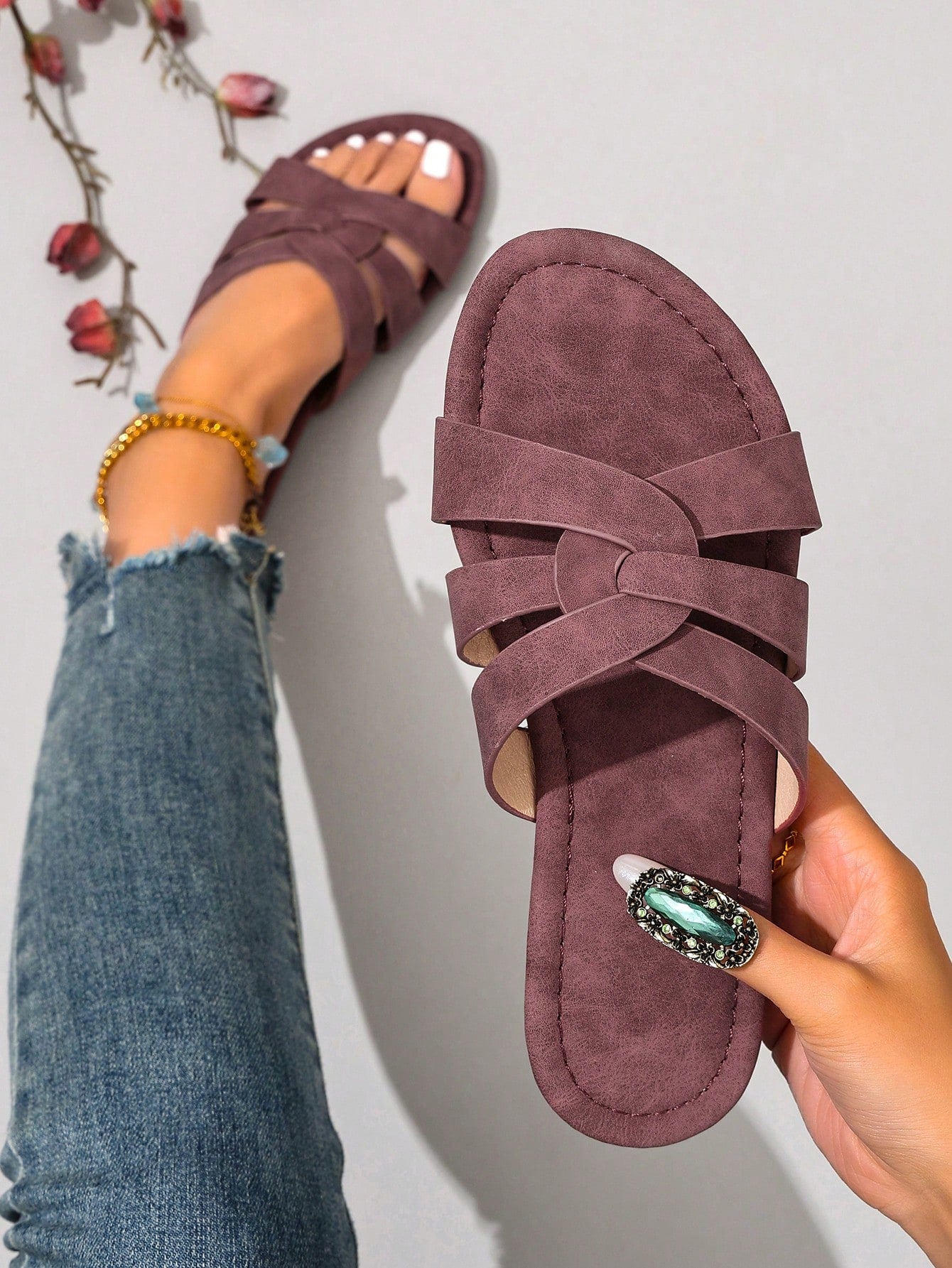Women’s flat open-toe slide sandals with braided strap detail, embossed texture, and rhinestone decoration, designed as casual slip-on footwear for beach and everyday outdoor wear.
