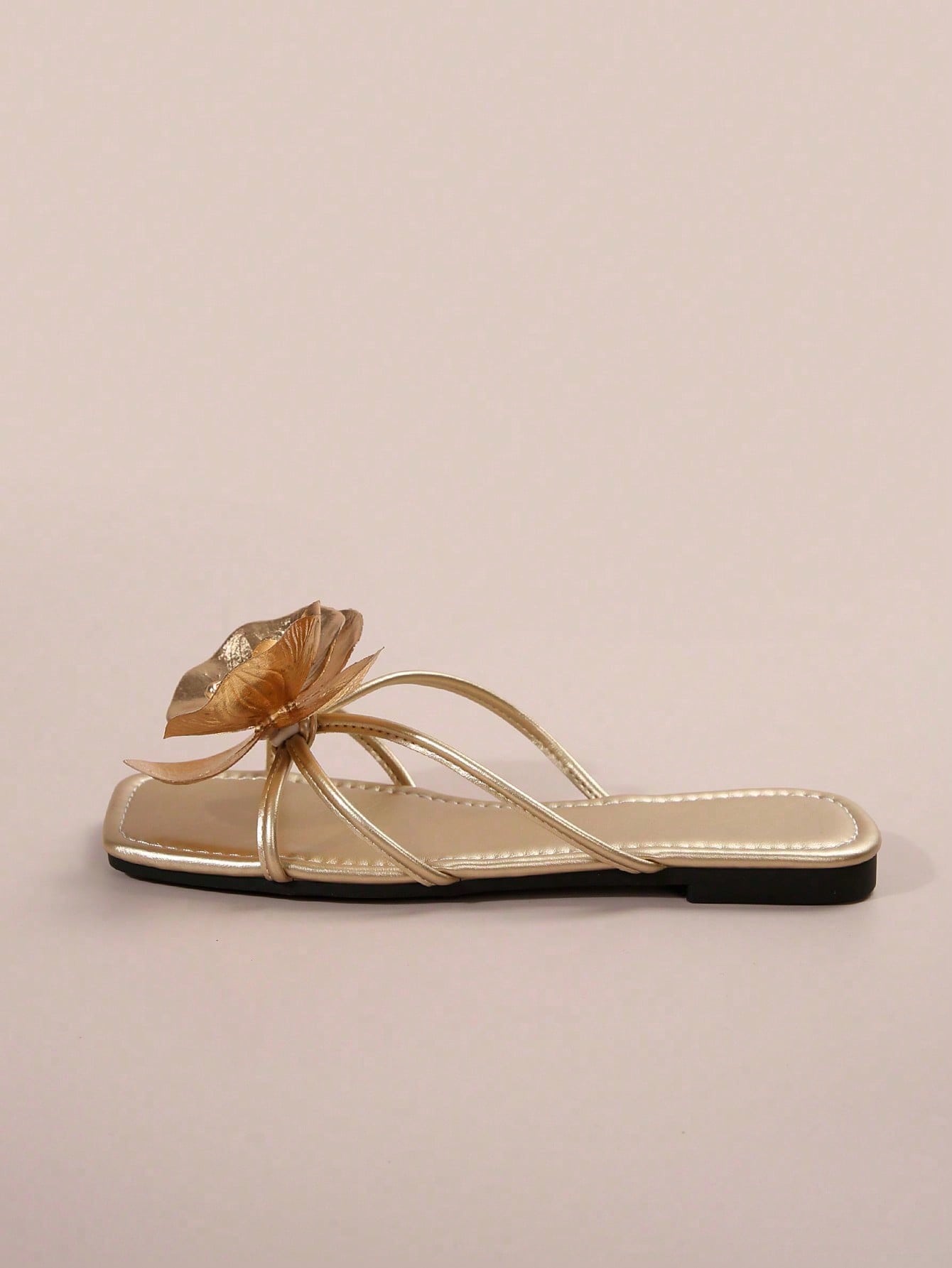 Women's flat slide sandals with open toe, floral applique detail, and criss-cross straps, shown as casual vacation-style summer footwear.