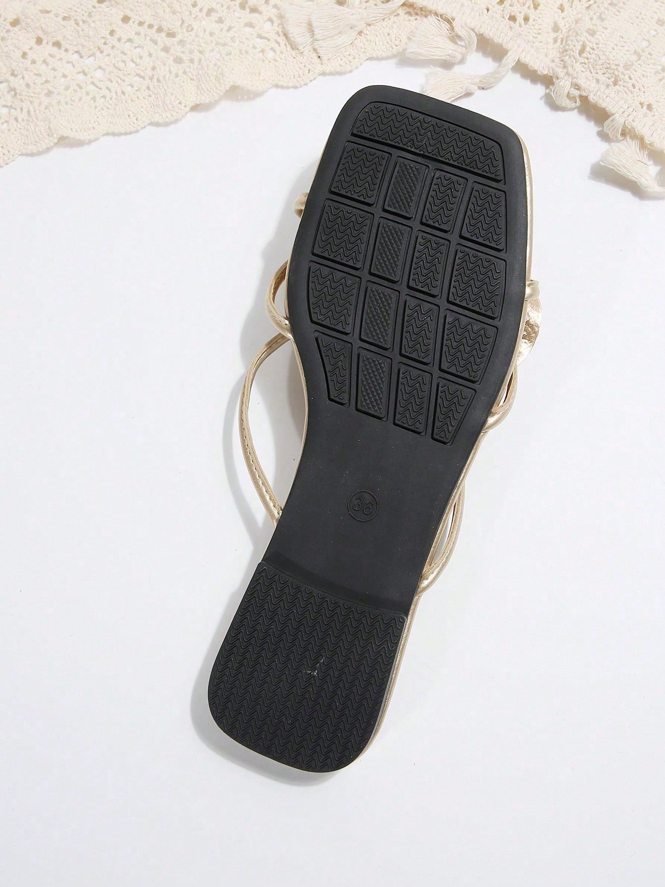 Women's flat slide sandals with open toe, floral applique detail, and criss-cross straps, shown as casual vacation-style summer footwear.