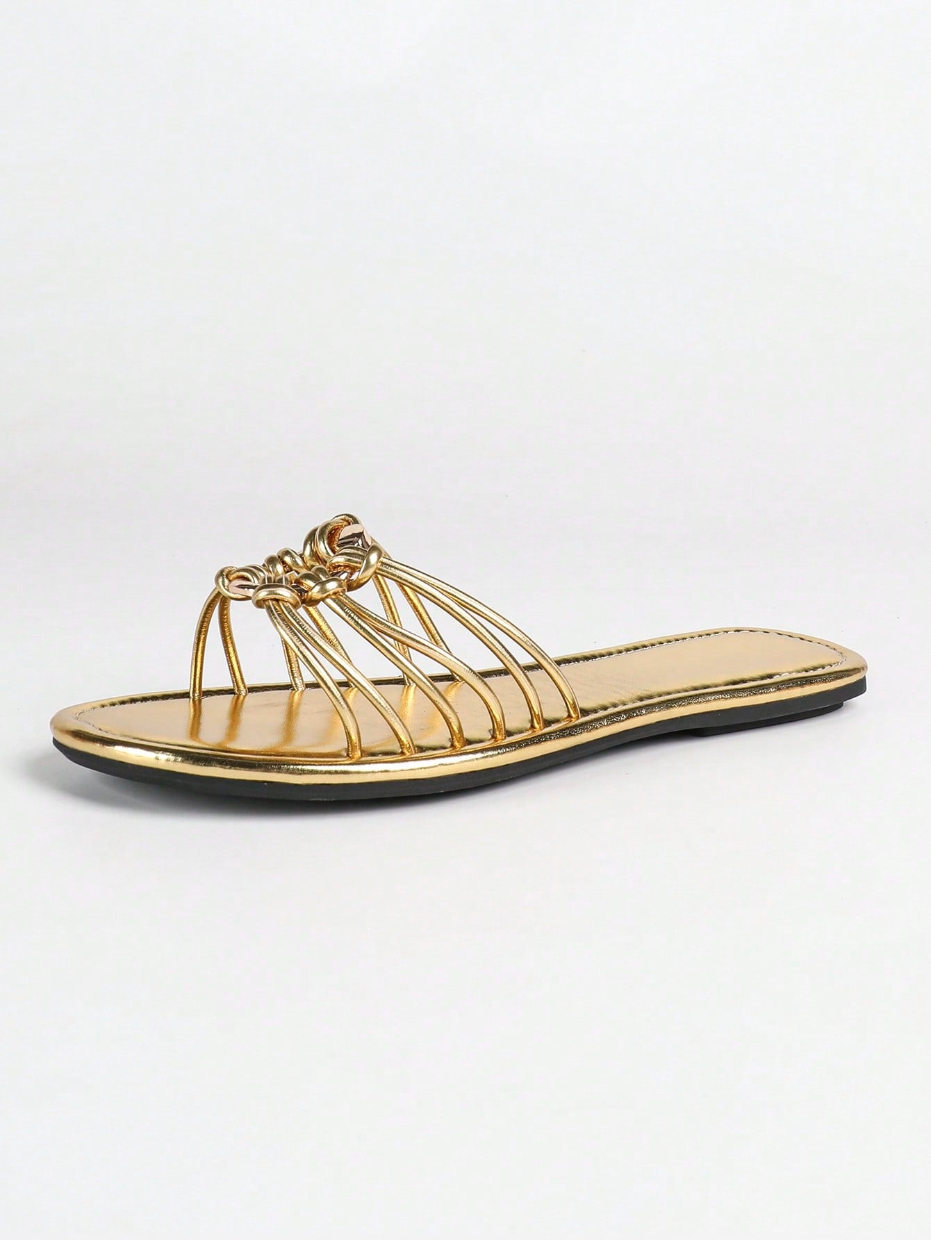 Women's gold flat sandals with metal accent detail, strappy lace-up design, and toe post thong style.
