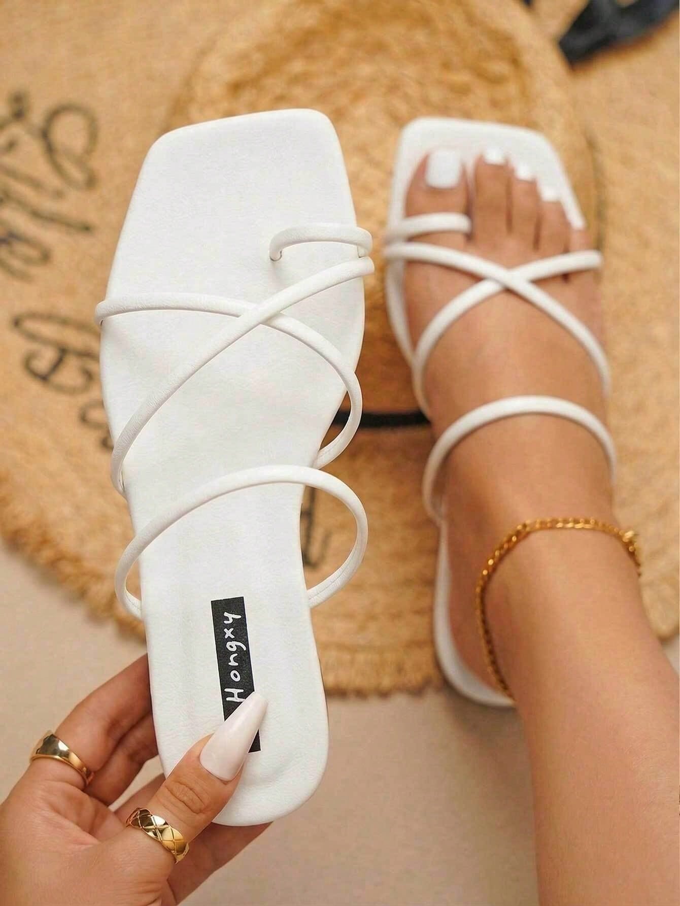 Women's slip-on flat slide sandals with bow tie decor, textured plain upper, and open toe.