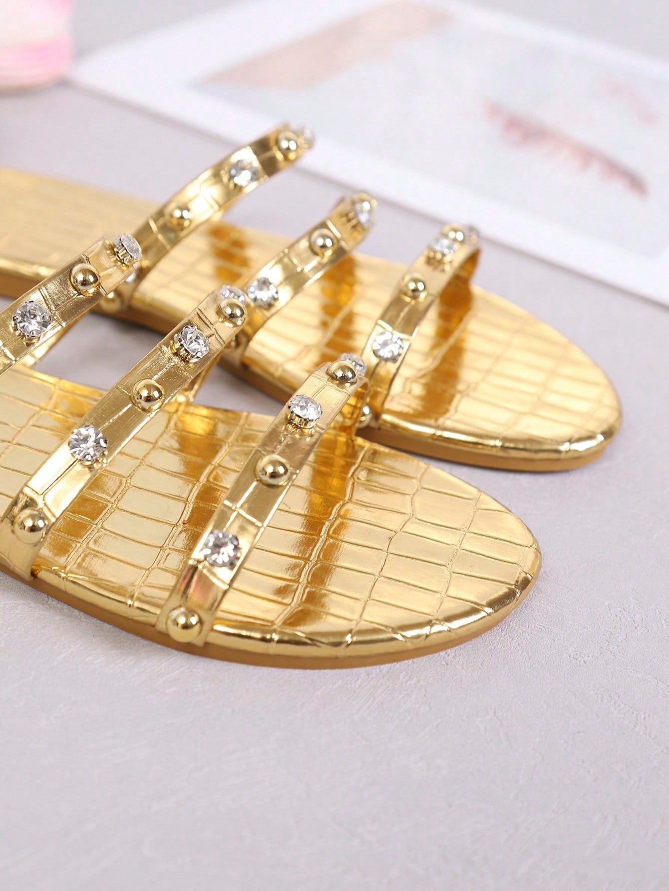 Women's gold crystal thong flip-flops with studded bohemian detailing, flat sole, and PU leather upper for casual indoor and outdoor beach wear.
