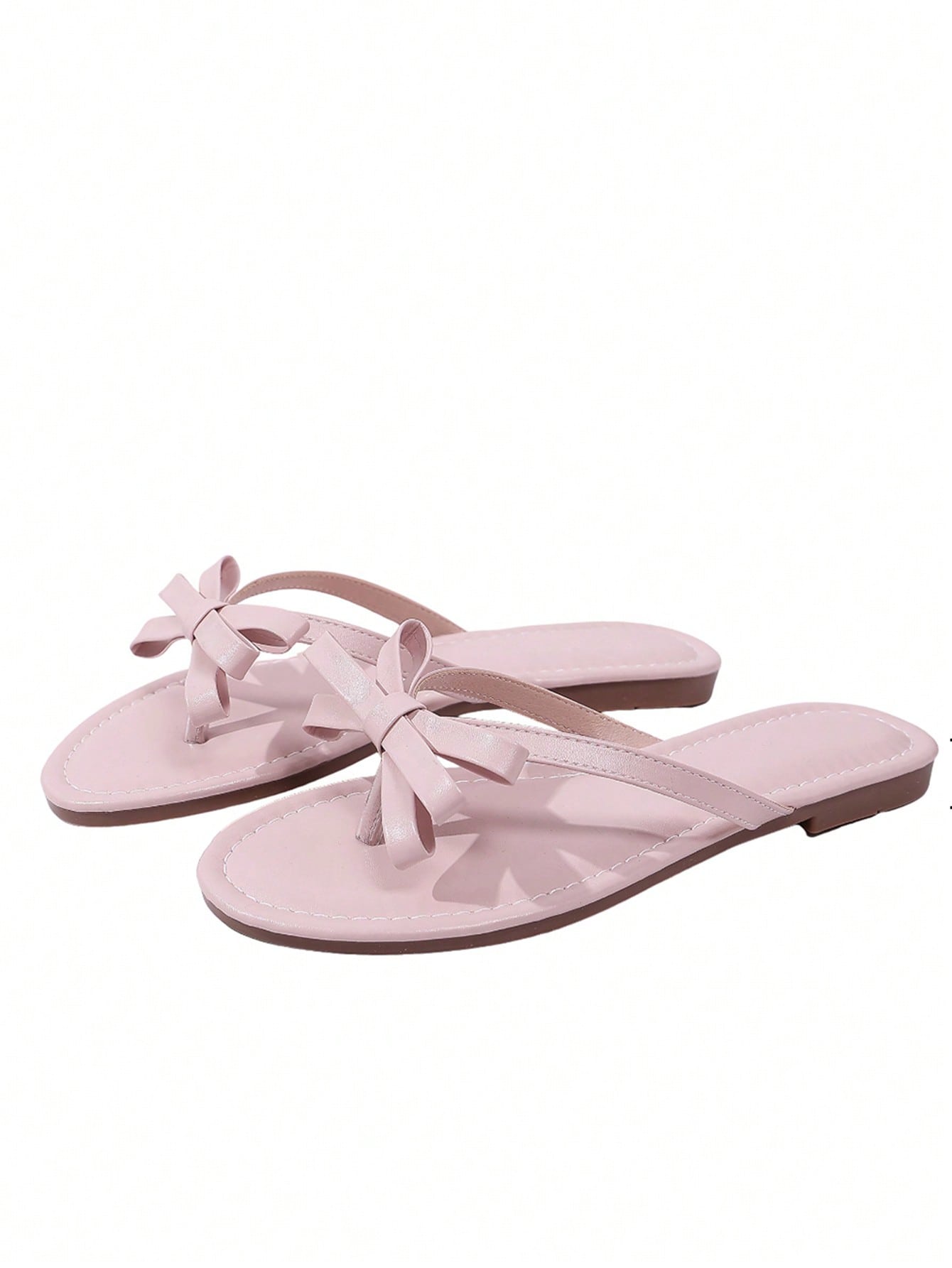 Women's flat slip-on slide sandals with textured PU leather look, bow detail on the upper, and toe-post design for casual vacation and beach wear.