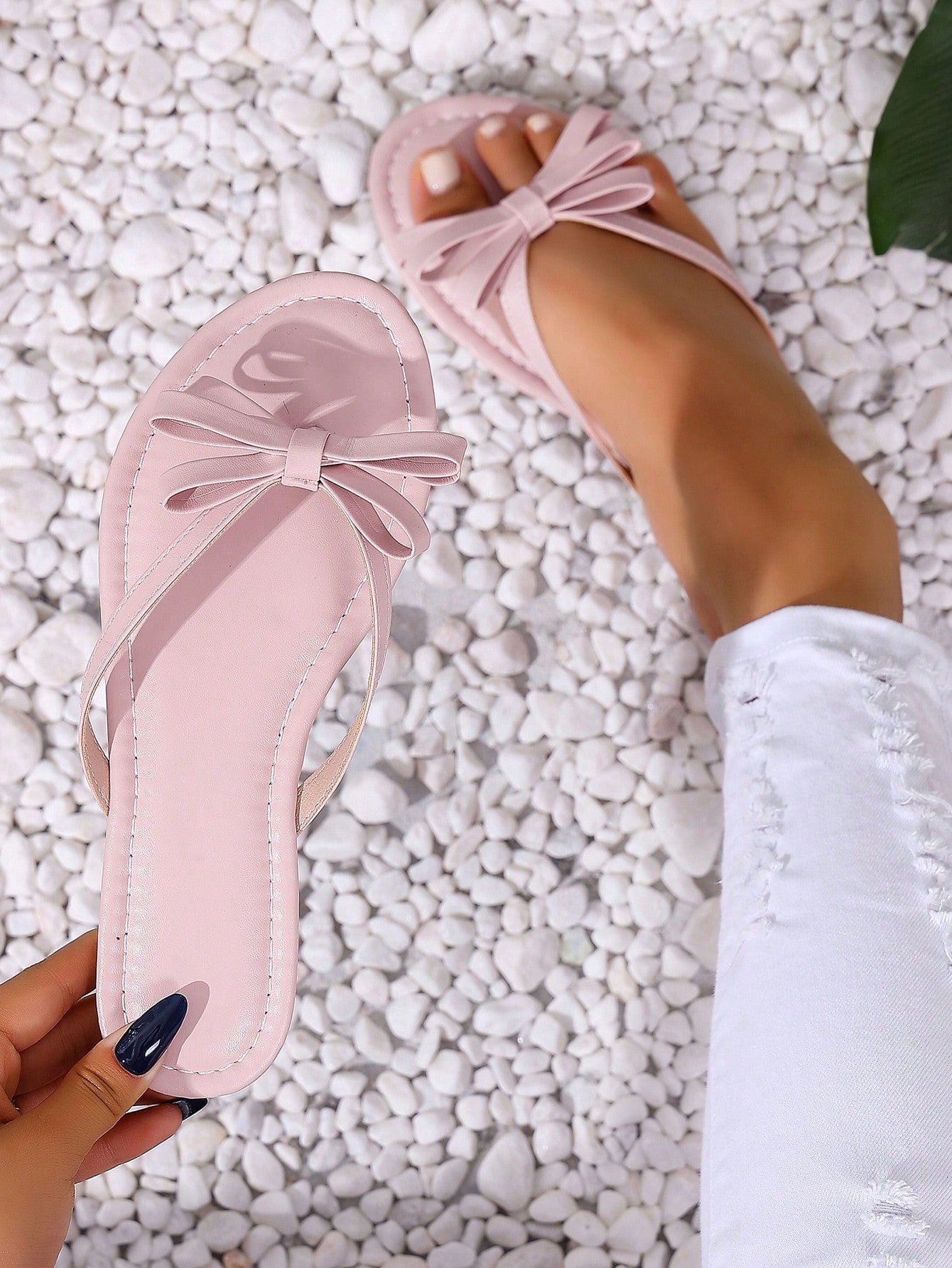 Women's flat slip-on slide sandals with textured PU leather look, bow detail on the upper, and toe-post design for casual vacation and beach wear.