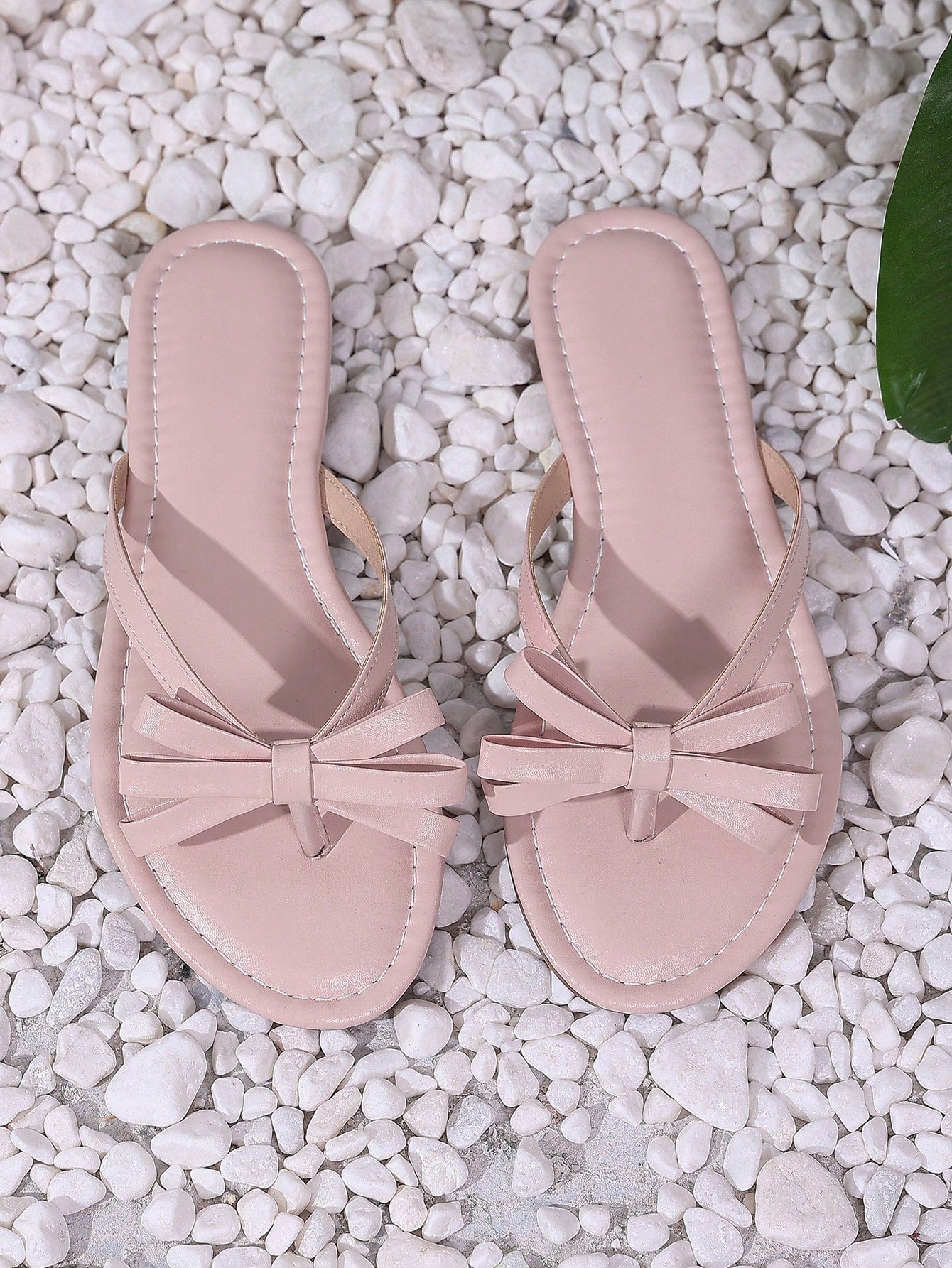 Women's flat slip-on slide sandals with textured PU leather look, bow detail on the upper, and toe-post design for casual vacation and beach wear.