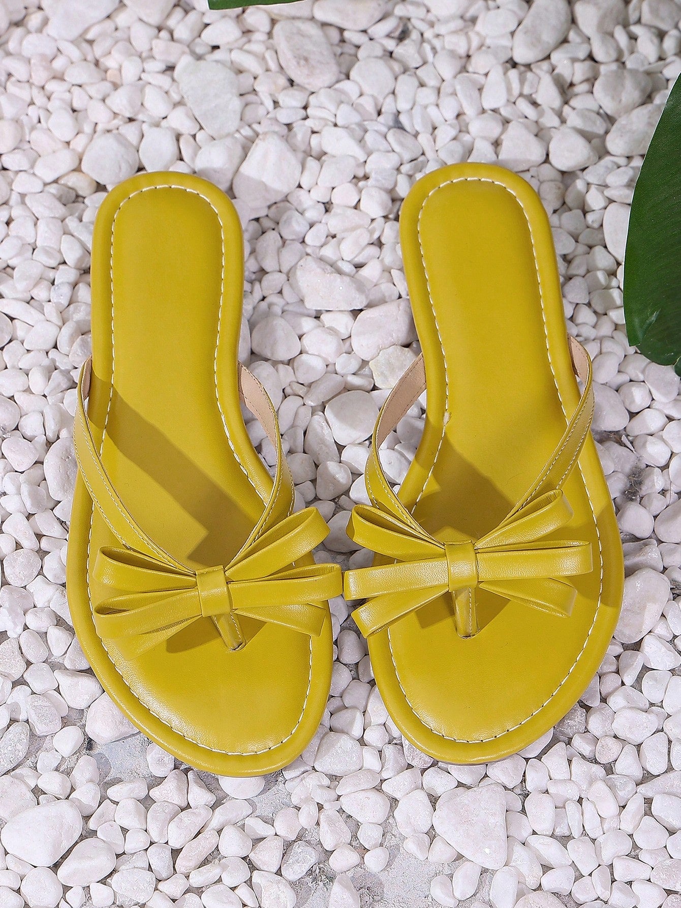 Women's flat slip-on slide sandals with textured PU leather look, bow detail on the upper, and toe-post design for casual vacation and beach wear.