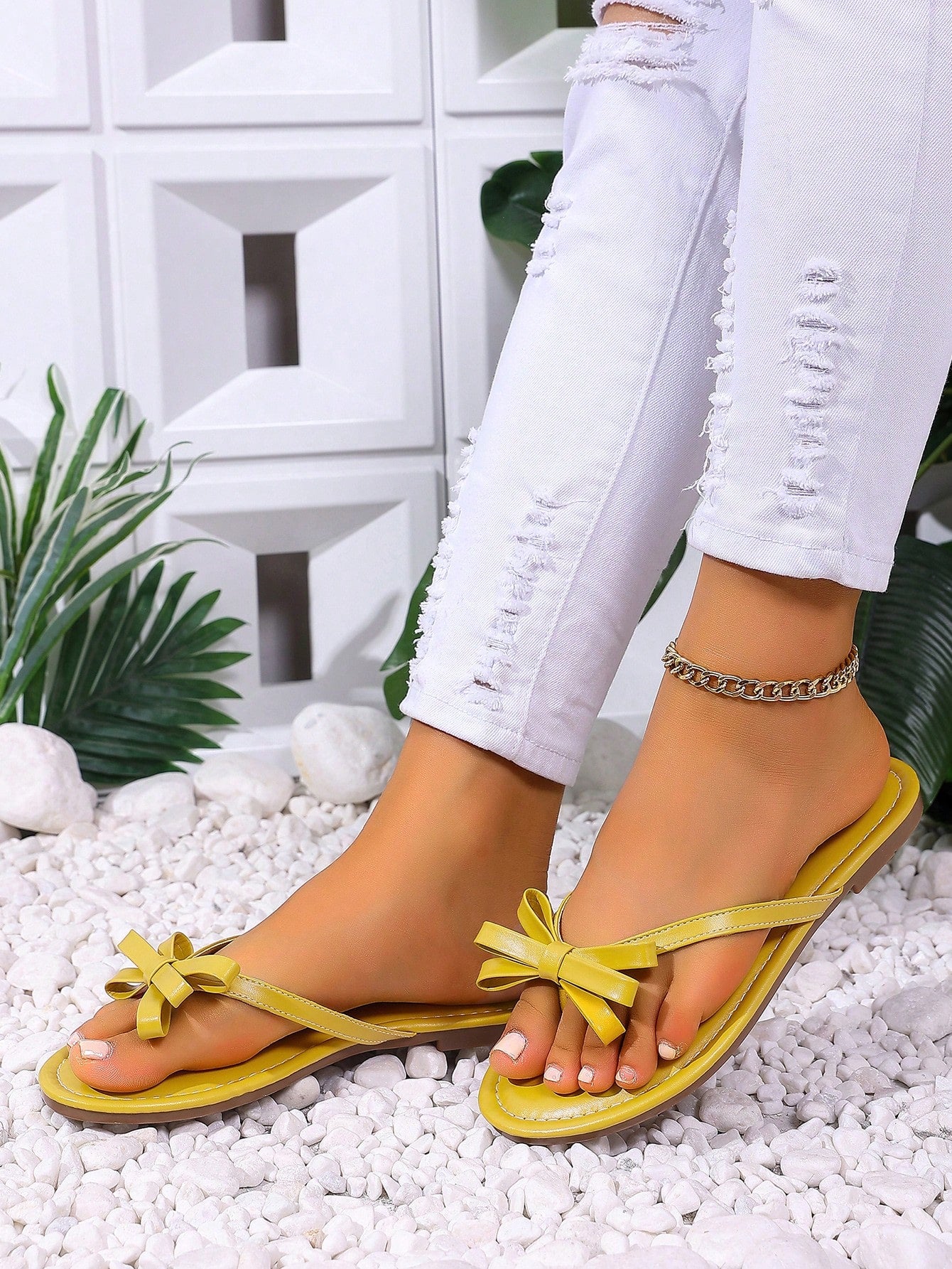 Women's flat slip-on slide sandals with textured PU leather look, bow detail on the upper, and toe-post design for casual vacation and beach wear.