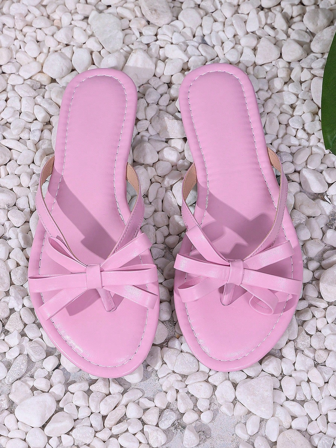 Women’s flat slide sandals with contrast mesh bow decoration and textured upper, open toe design, and slip-on style for beach and vacation wear.