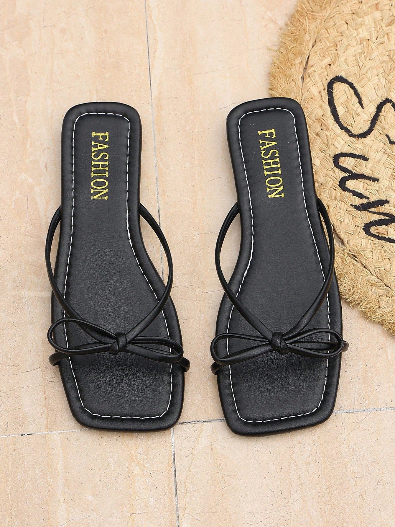 Women’s black flat slip-on sandals with a toe post and striped bow decoration, casual vacation and beach slide style.