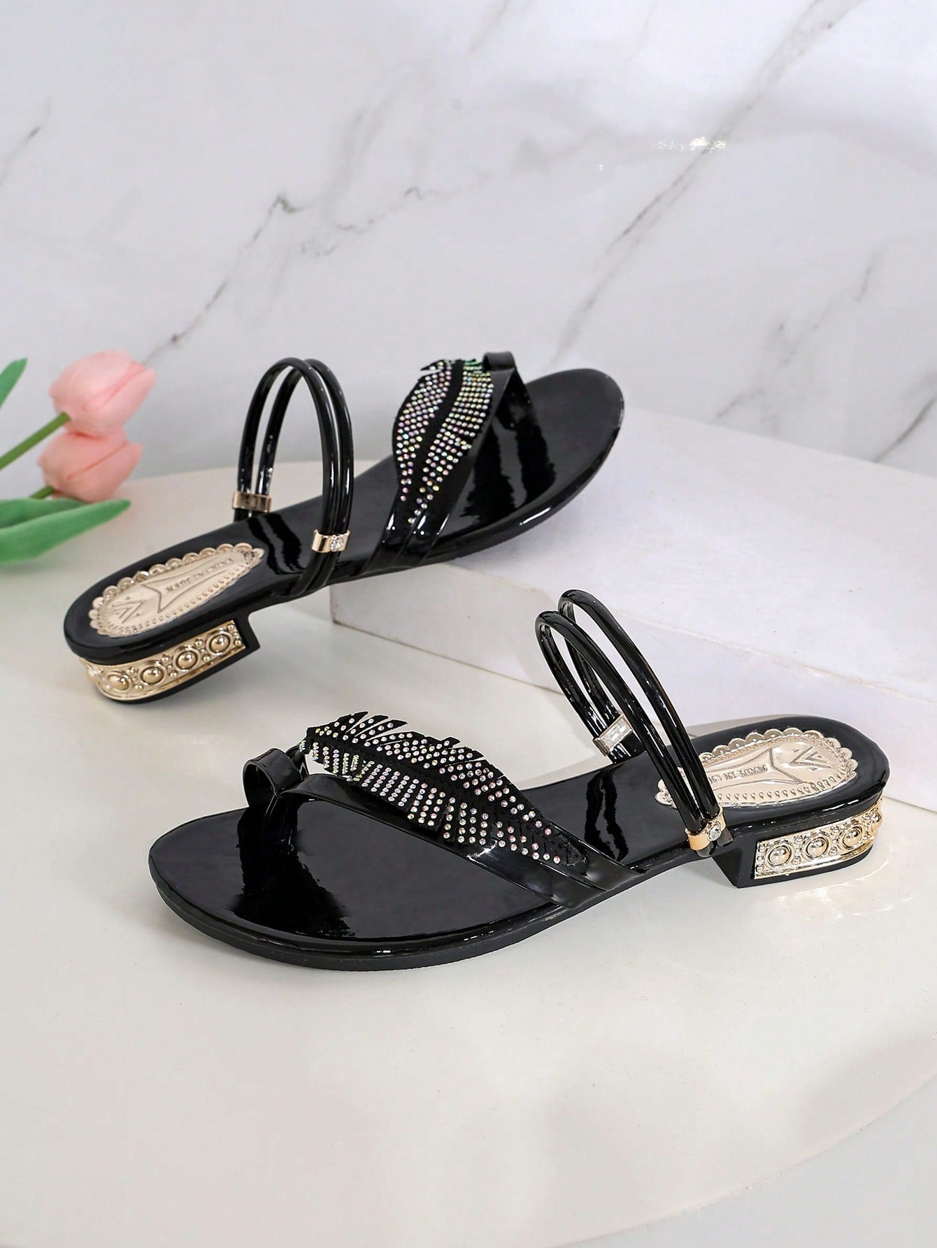 Open-toe flat slide sandals featuring rhinestone leaf decoration in a vacation-inspired style.