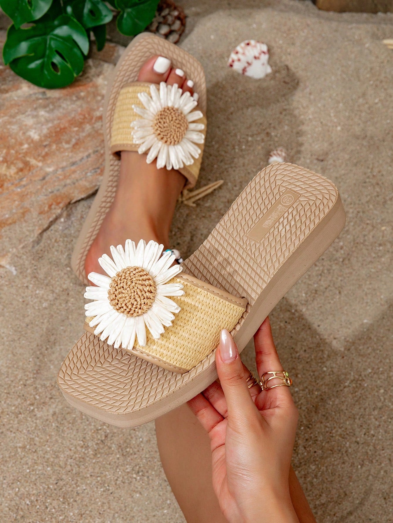 Women’s flat linen flip-flops with flower appliqué decor and sole, beach slipper style.