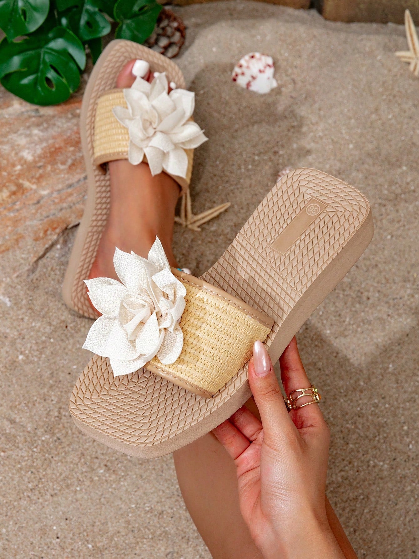 Women’s flat linen flip-flops with flower appliqué decor and sole, beach slipper style.