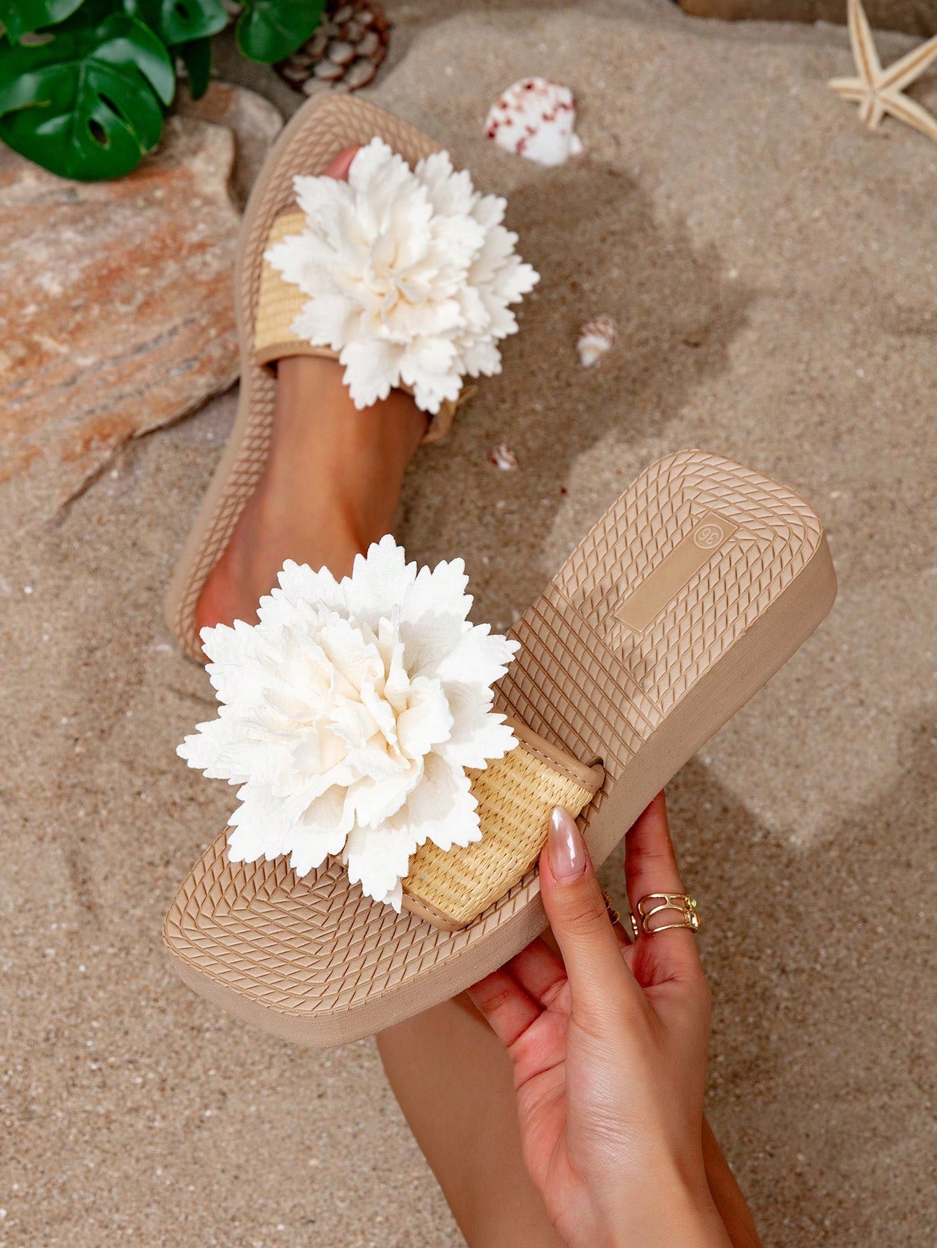 Women’s flat linen flip-flops with flower appliqué decor and sole, beach slipper style.