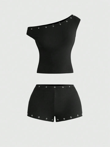 Women's two-piece outfit with an asymmetric neck studded grommet crop top and super low-rise mini shorts
