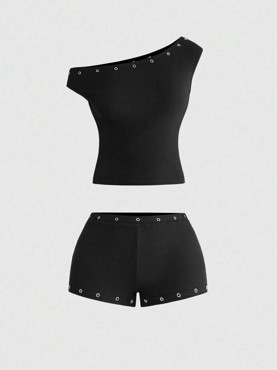 Women's two-piece outfit with an asymmetric neck studded grommet crop top and super low-rise mini shorts