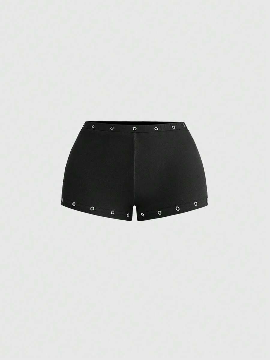 Women's two-piece outfit with an asymmetric neck studded grommet crop top and super low-rise mini shorts