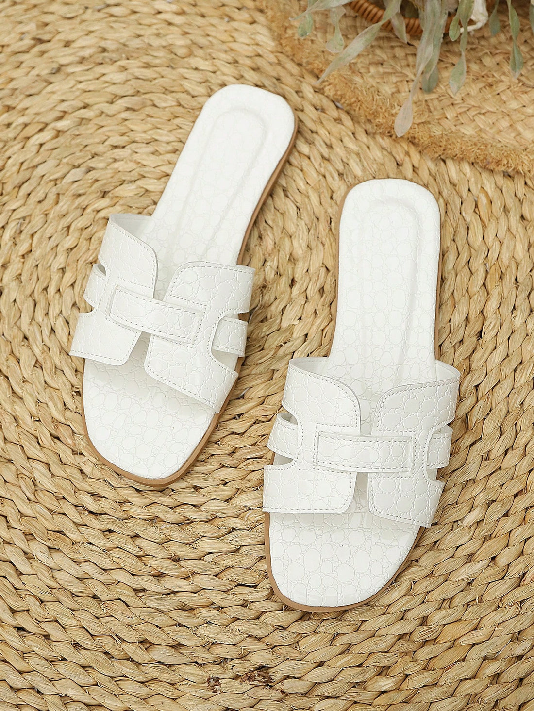 Women's flat open-toe beach sandals with criss-cross and cut-out upper design, suitable for seaside travel and casual summer wear.