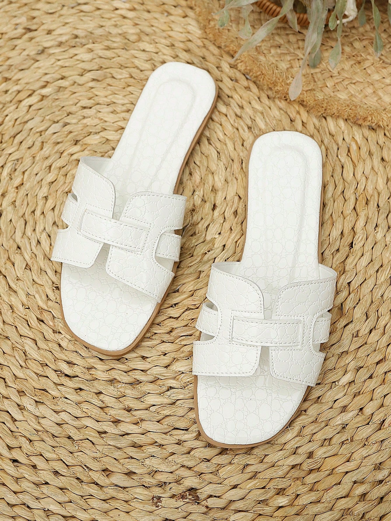 Women's flat open-toe beach sandals with criss-cross and cut-out upper design, suitable for seaside travel and casual summer wear.