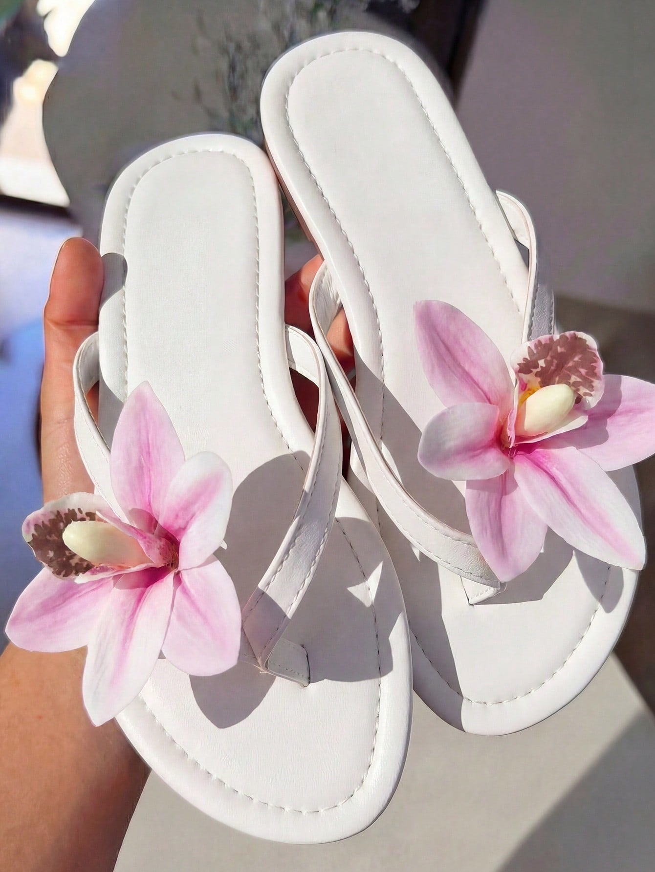 Women's black flat slide sandals with toe post design, textured PU leather straps, and rhinestone heart decoration.