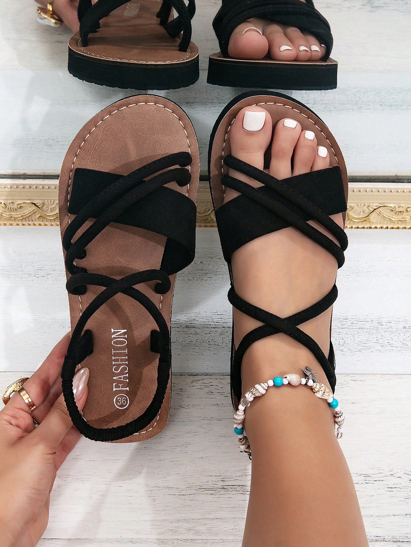 Women's colorblock flat slide sandals with criss cross strap, toe post, cloth tape and fleece detail, finished with sequin, crystal, gemstone, and knot accents.