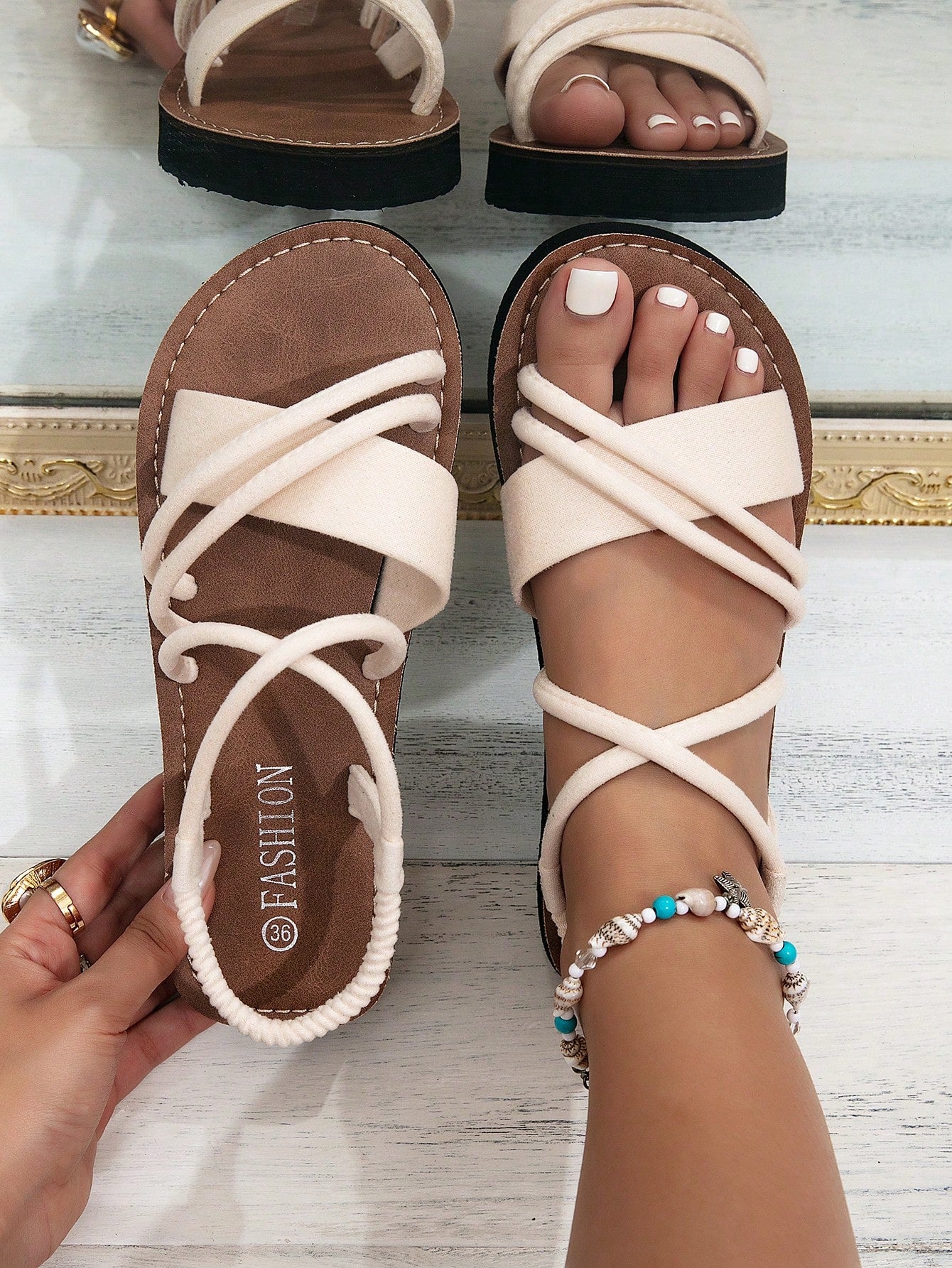 Women's colorblock flat slide sandals with criss cross strap, toe post, cloth tape and fleece detail, finished with sequin, crystal, gemstone, and knot accents.