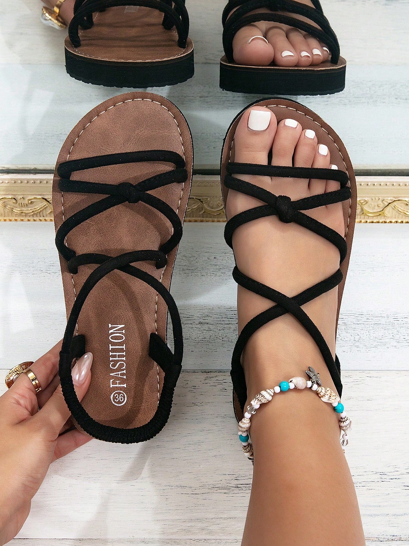 Women's colorblock flat slide sandals with criss cross strap, toe post, cloth tape and fleece detail, finished with sequin, crystal, gemstone, and knot accents.