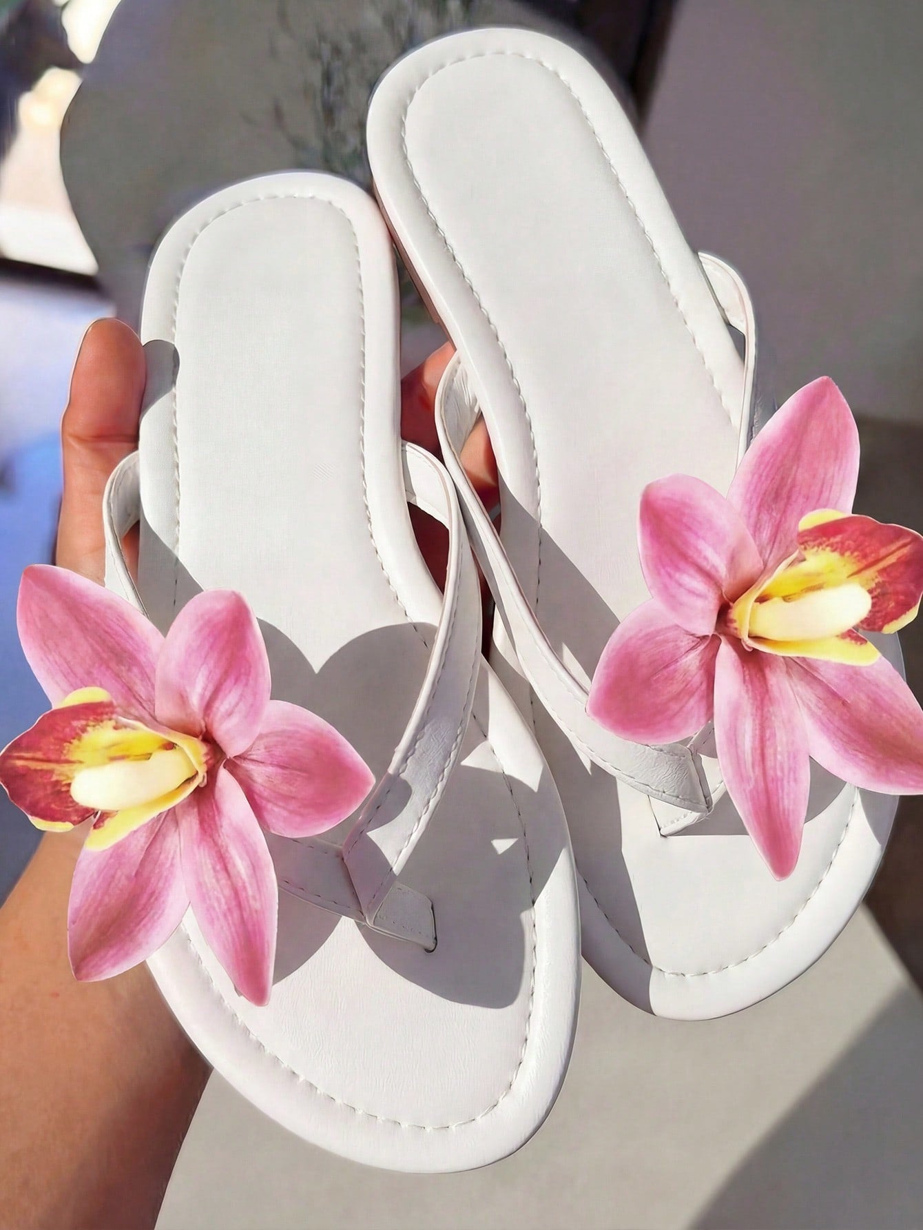 Women's black flat slide sandals with toe post design, textured PU leather straps, and rhinestone heart decoration.