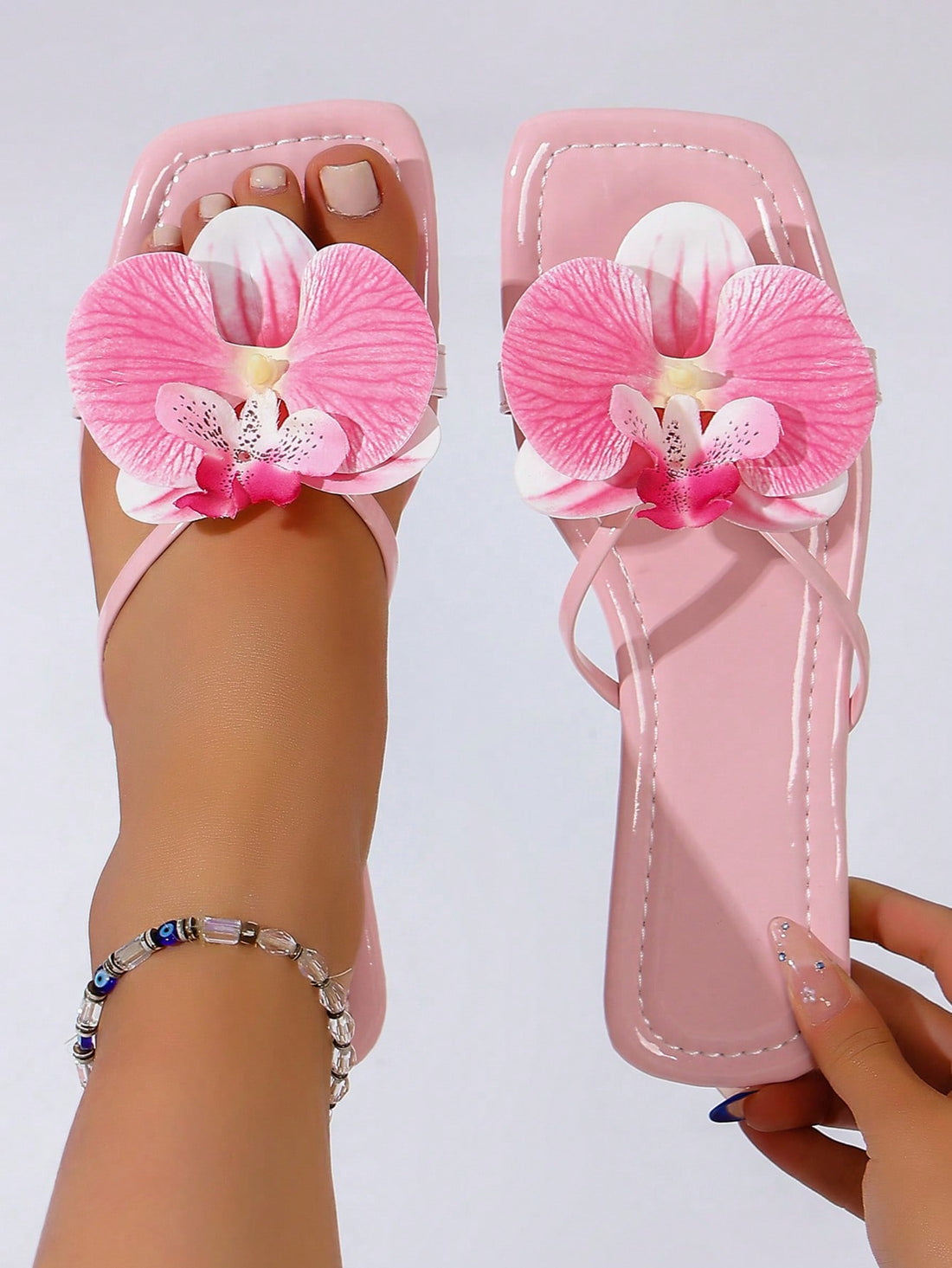 Women's orchid flower flat slide sandals with open toe design, vacation style slippers for outdoor fashion wear.