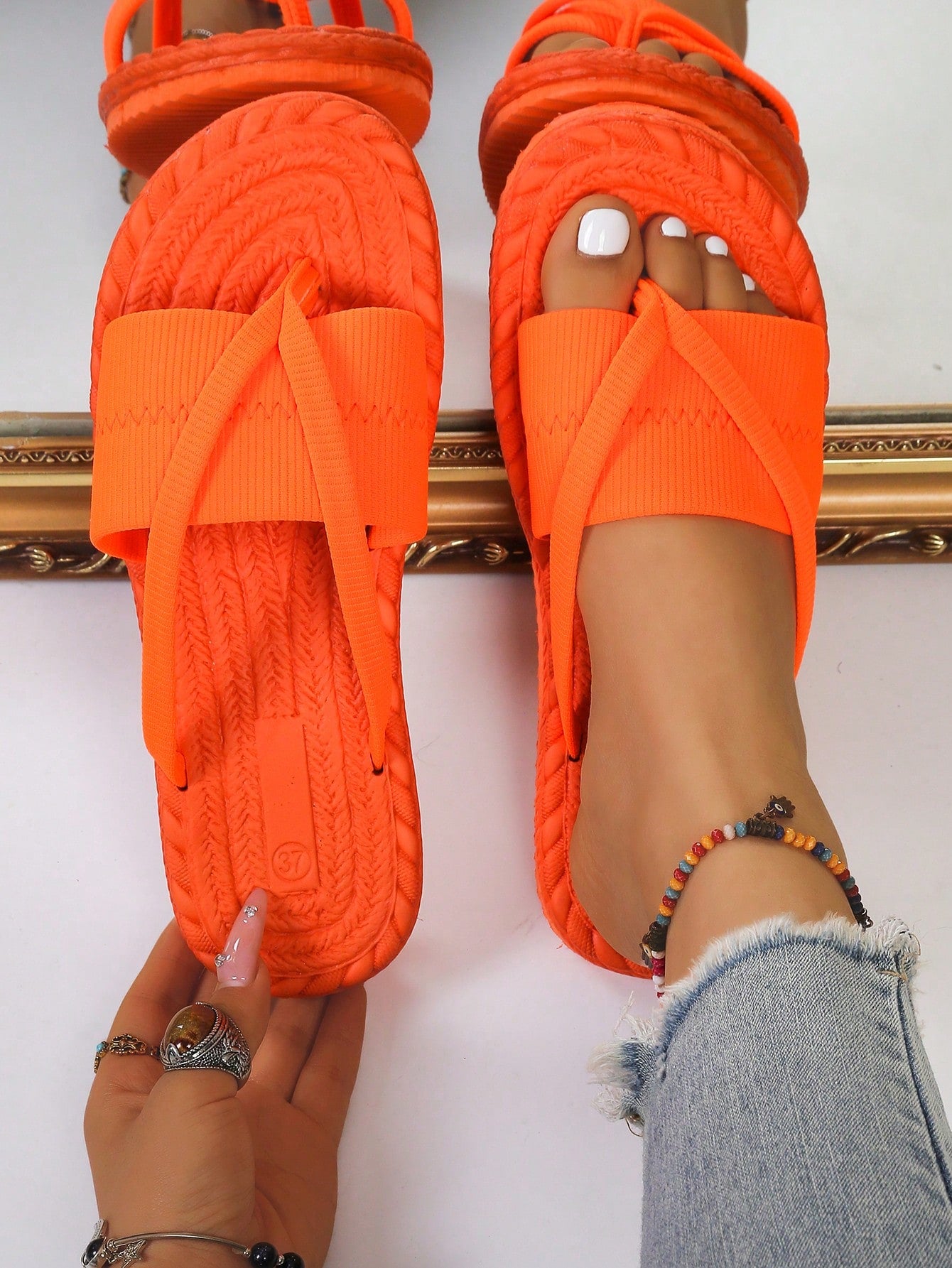 Women's open-toe flat beach sandals with toe ring strap and bow decoration, lightweight slip-on style for vacation and outdoor use.