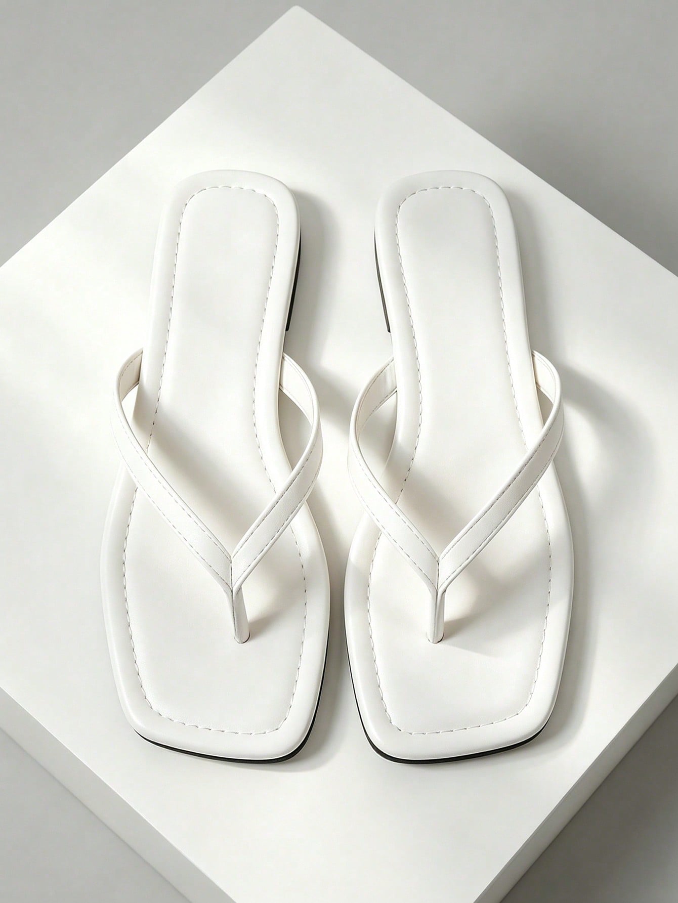 Women's black flat slide sandals with toe post design, textured PU leather straps, and rhinestone heart decoration.