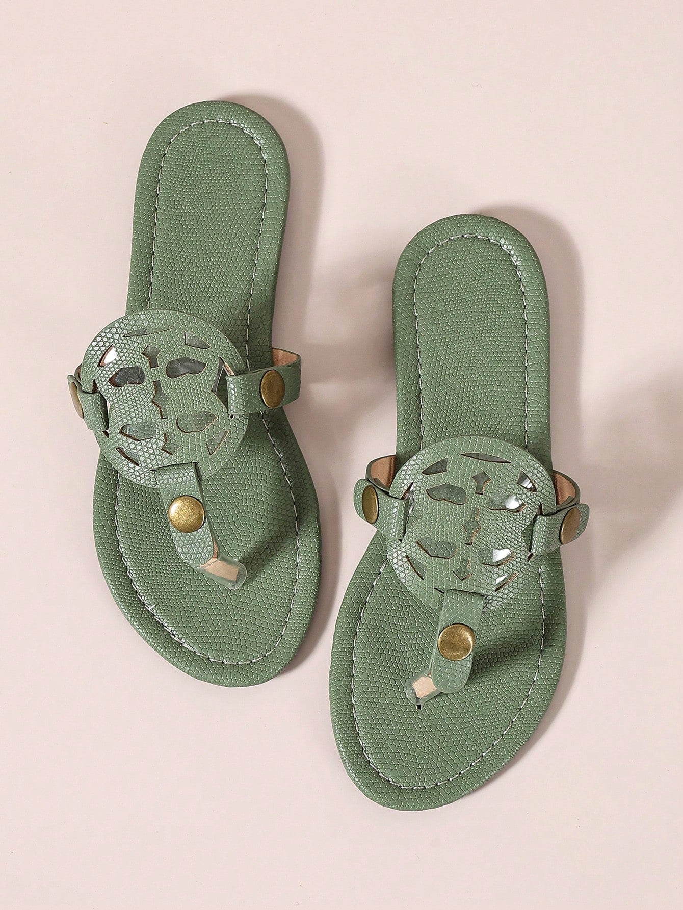 Pair of women’s open-toe flat slide sandals with an H-shaped strap, braided and embossed details, and a minimalist slip-on design suitable for casual outdoor wear.