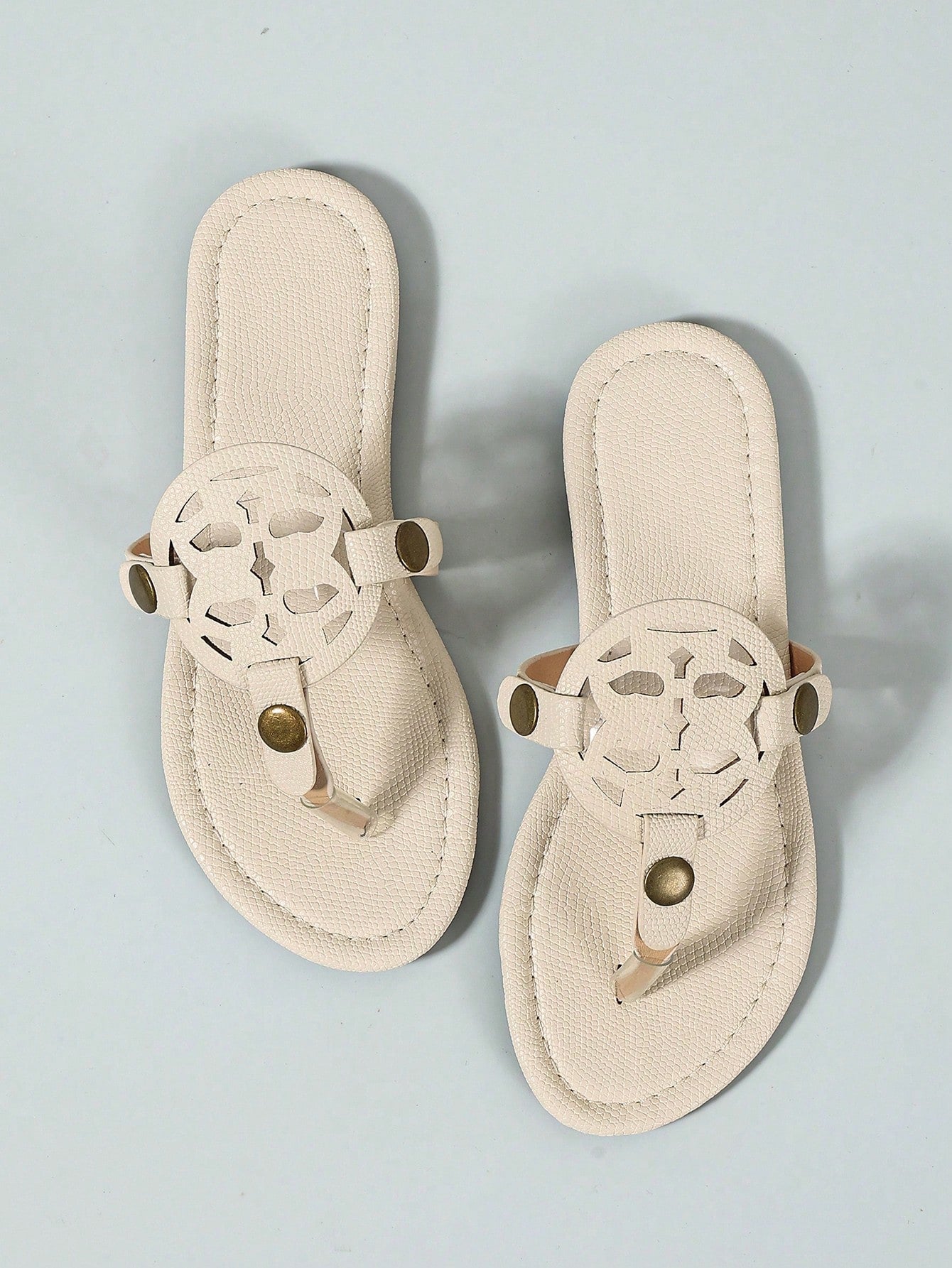 Women’s flat open-toe slide sandals with braided strap detail, embossed texture, and rhinestone decoration, designed as casual slip-on footwear for beach and everyday outdoor wear.