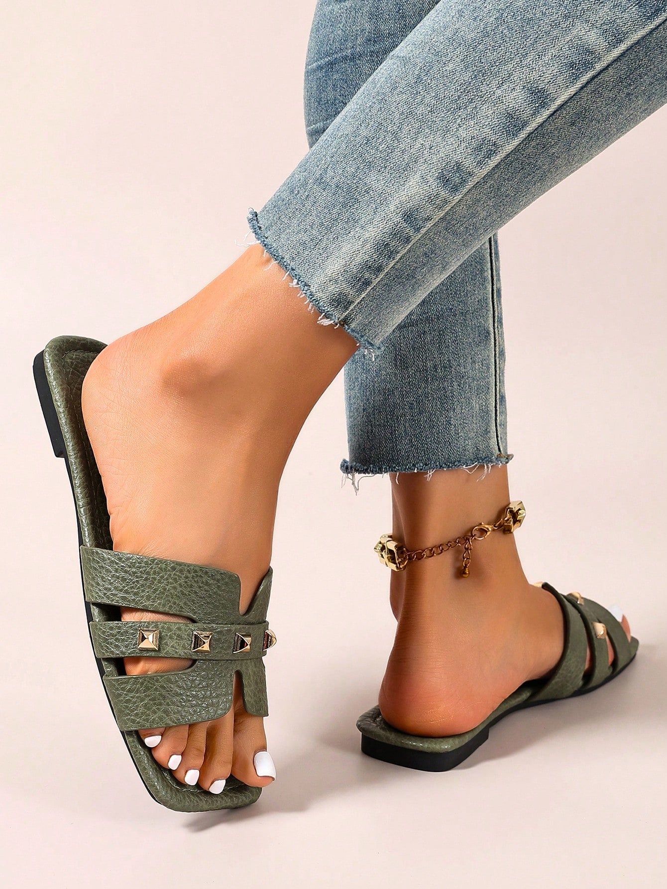 Pair of women’s open-toe flat slide sandals with an H-shaped strap, braided and embossed details, and a minimalist slip-on design suitable for casual outdoor wear.