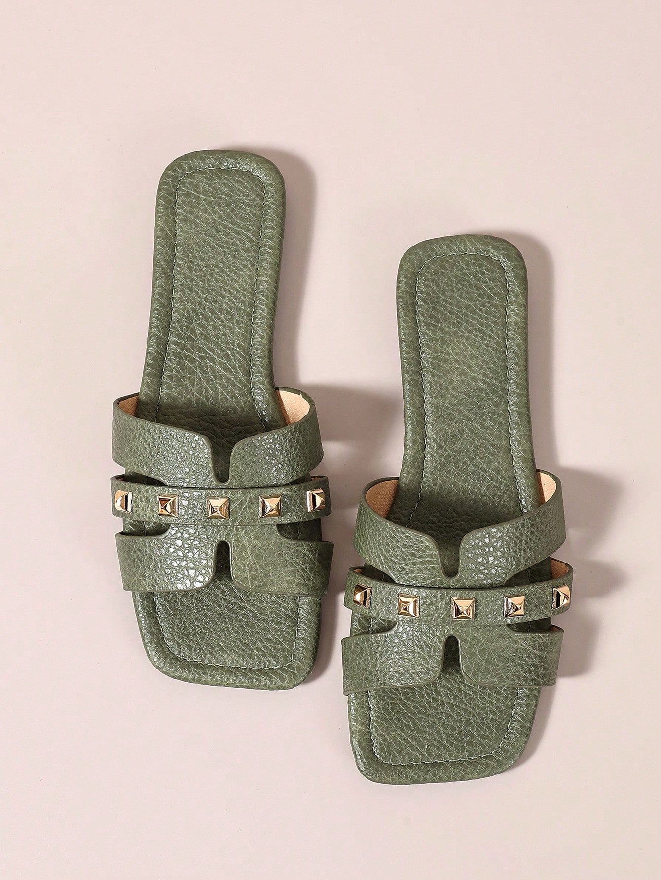 Pair of women’s open-toe flat slide sandals with an H-shaped strap, braided and embossed details, and a minimalist slip-on design suitable for casual outdoor wear.