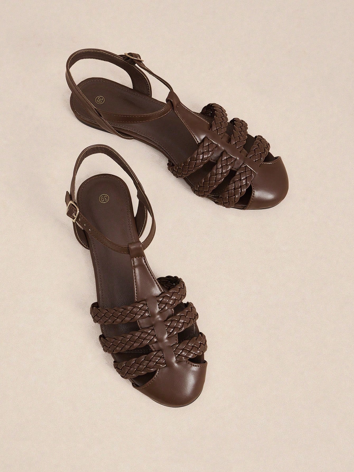 Women's flat gladiator sandals featuring a hollow-out multi-strap woven design and ankle strap style, with striped pattern and casual beach vacation look.
