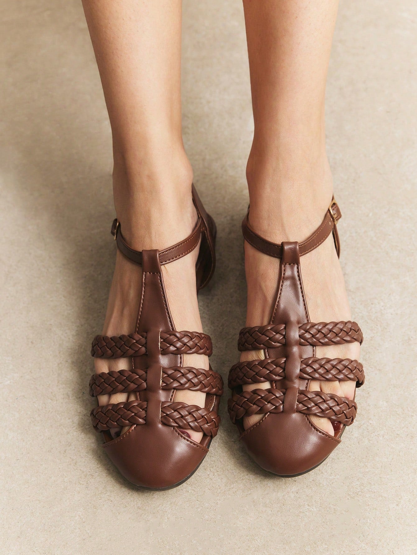 Women's flat gladiator sandals featuring a hollow-out multi-strap woven design and ankle strap style, with striped pattern and casual beach vacation look.