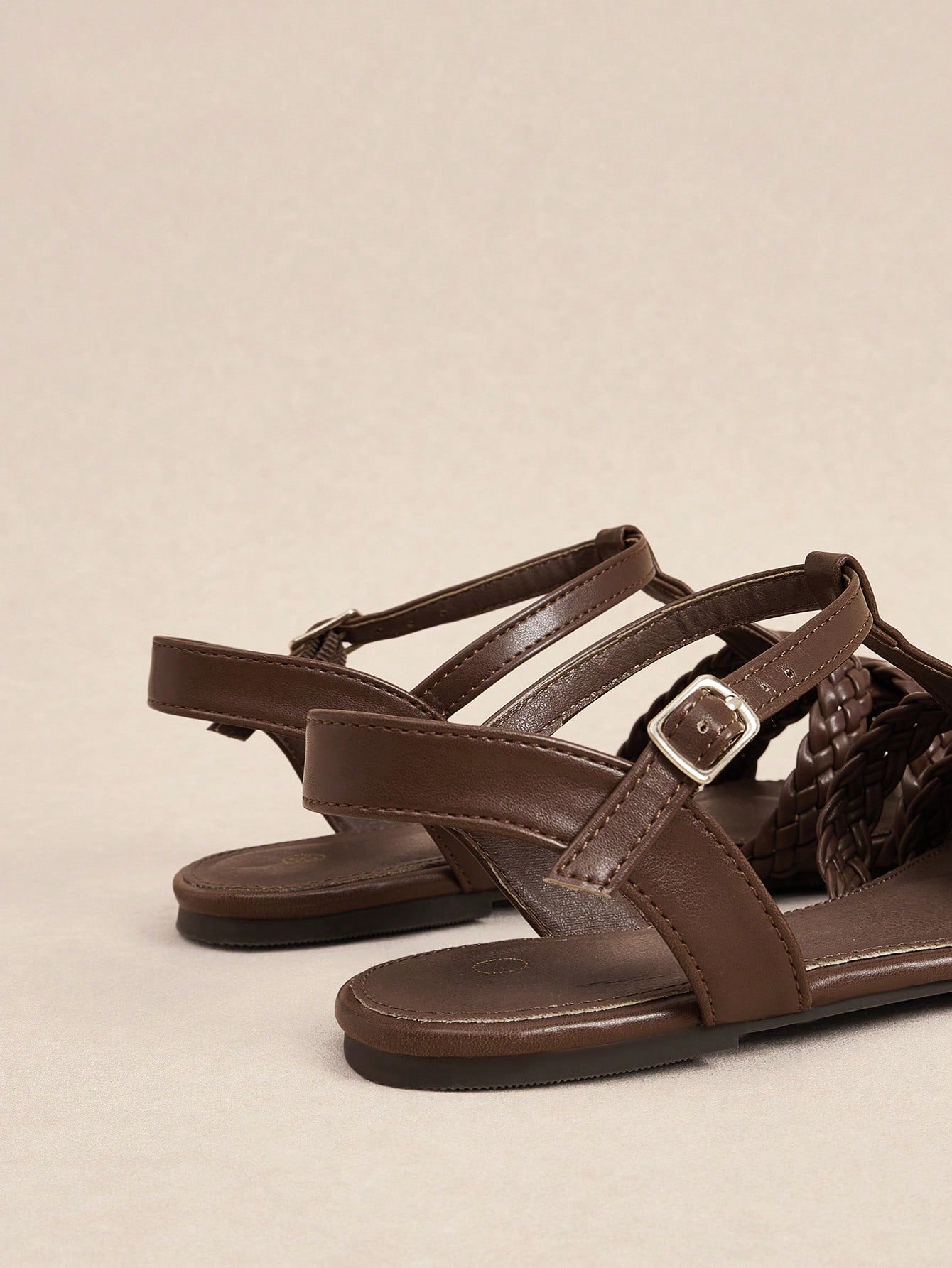 Women's flat gladiator sandals featuring a hollow-out multi-strap woven design and ankle strap style, with striped pattern and casual beach vacation look.
