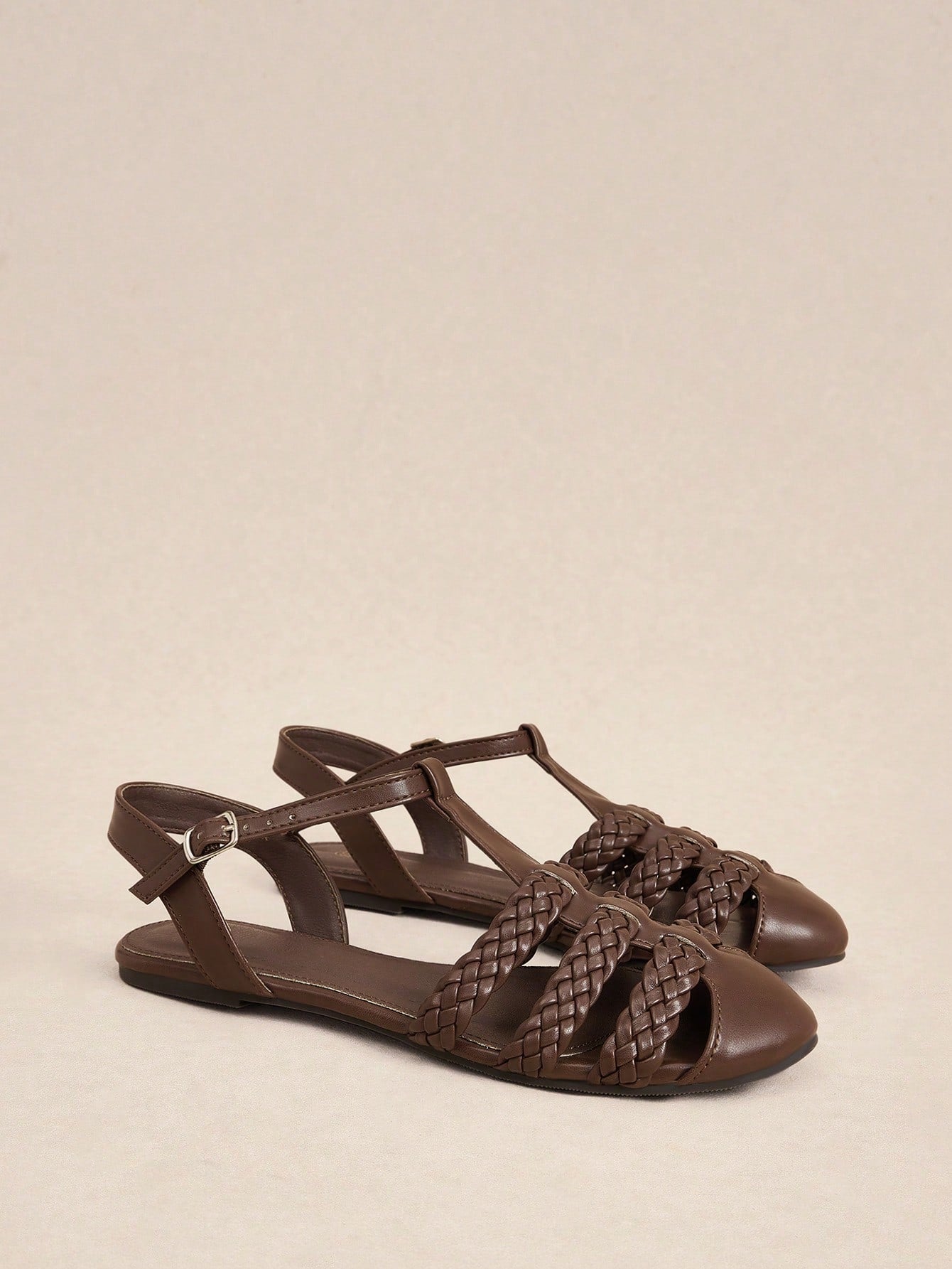 Women's flat gladiator sandals featuring a hollow-out multi-strap woven design and ankle strap style, with striped pattern and casual beach vacation look.