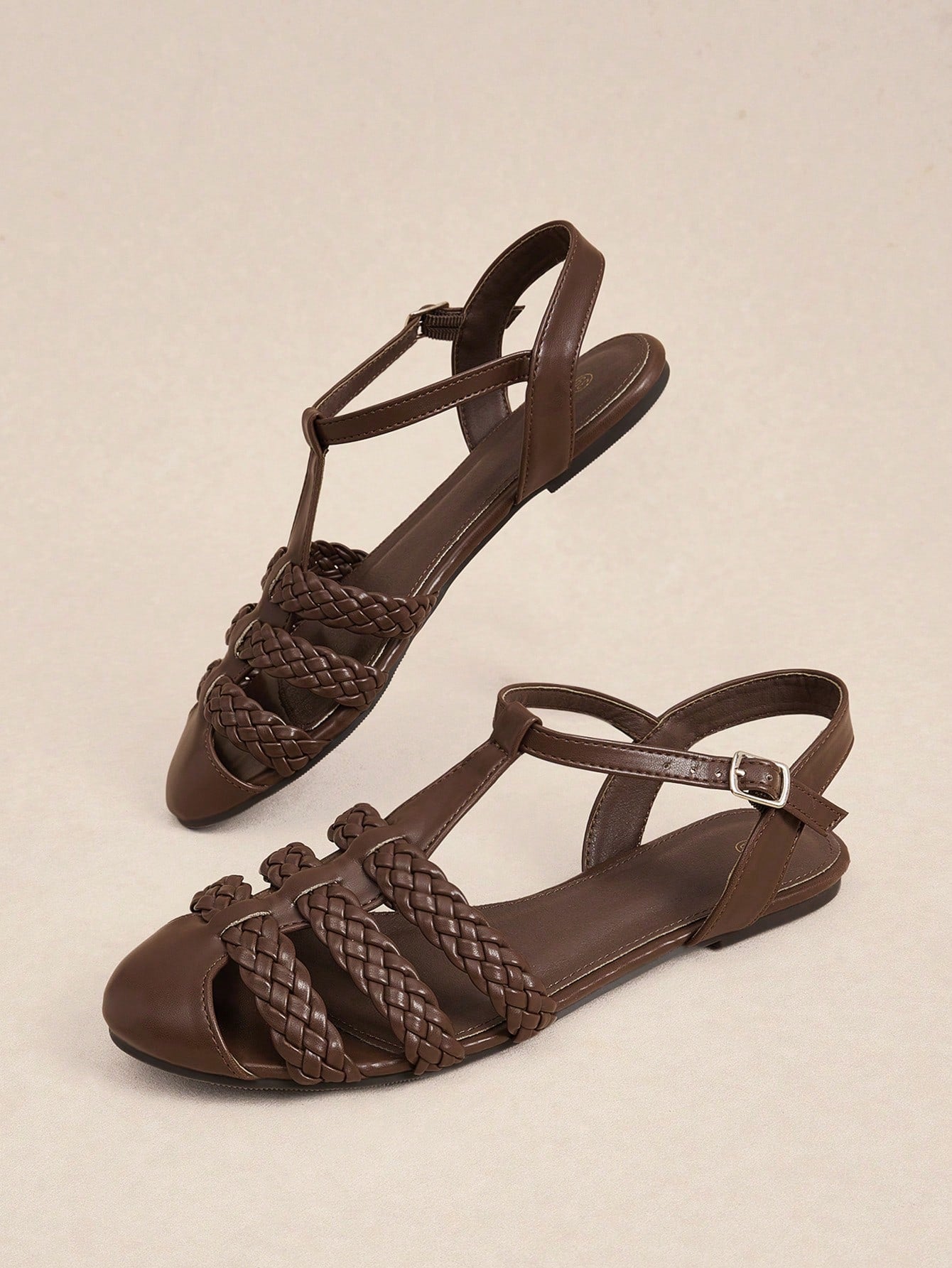 Women's flat gladiator sandals featuring a hollow-out multi-strap woven design and ankle strap style, with striped pattern and casual beach vacation look.